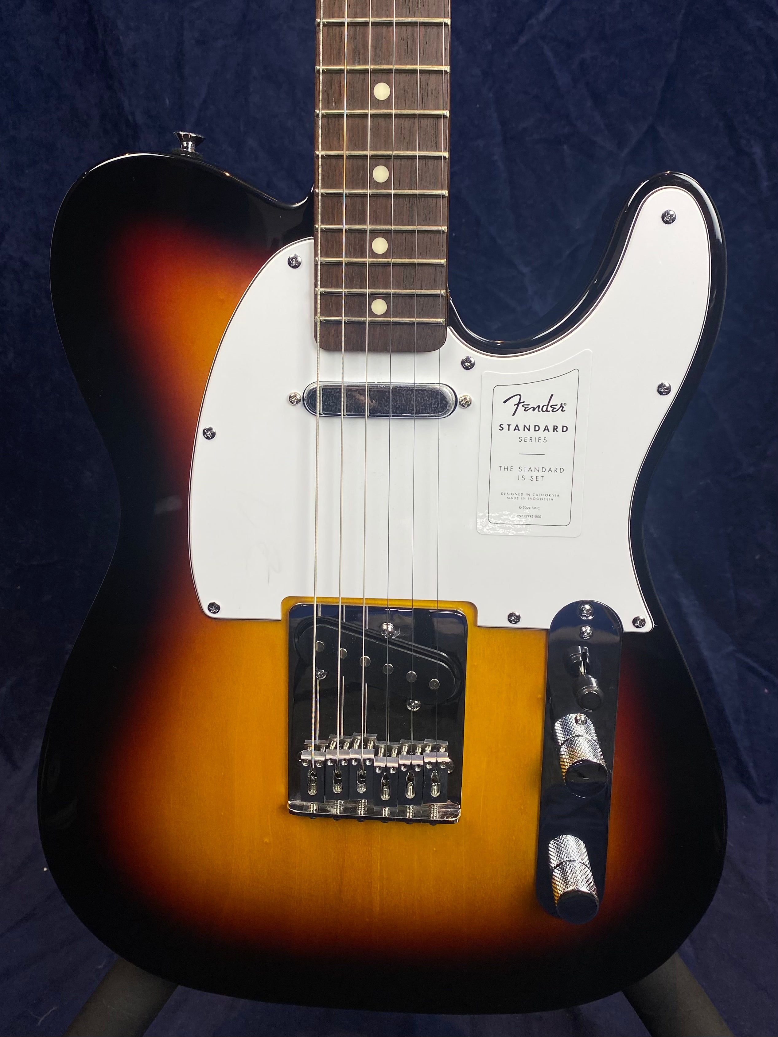Fender Standard Series electric guitar with a sunburst finish, white pickguard, two pickups, and chrome control knobs.