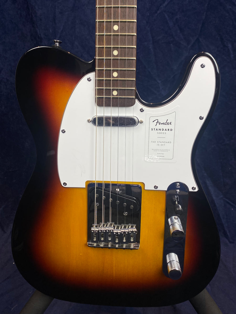 Fender Standard Series electric guitar with a sunburst finish, white pickguard, two pickups, and chrome control knobs.