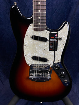 Fender electric guitar with a sunburst finish, white pearloid pickguard, two black pickups, chrome bridge, and black control knobs.