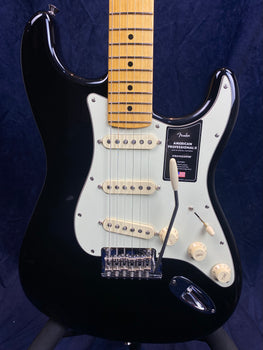 Black Fender Stratocaster electric guitar with white pickguard, three single-coil pickups, maple neck, and cream control knobs.