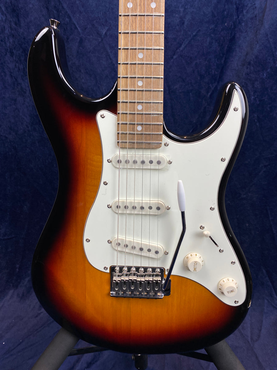 Sunburst-finish electric guitar with a white pickguard, three single-coil pickups, volume and tone knobs, and a tremolo arm.