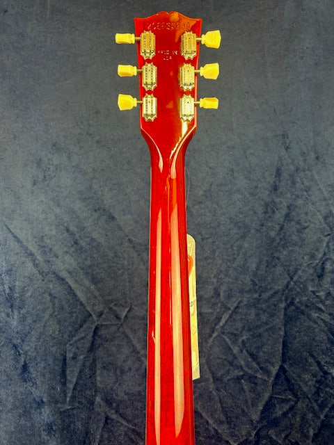 Bright red electric guitar neck and headstock with six vintage-style tuning pegs, viewed from the back against a dark background.