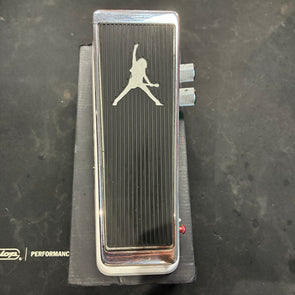 Black and chrome FX pedal with a silhouette of a person playing guitar engraved on top, two side knobs, and a red LED indicator.