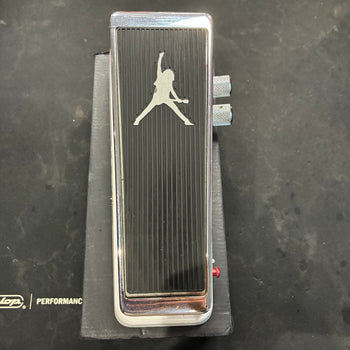 Black and chrome FX pedal with a silhouette of a person playing guitar engraved on top, two side knobs, and a red LED indicator.
