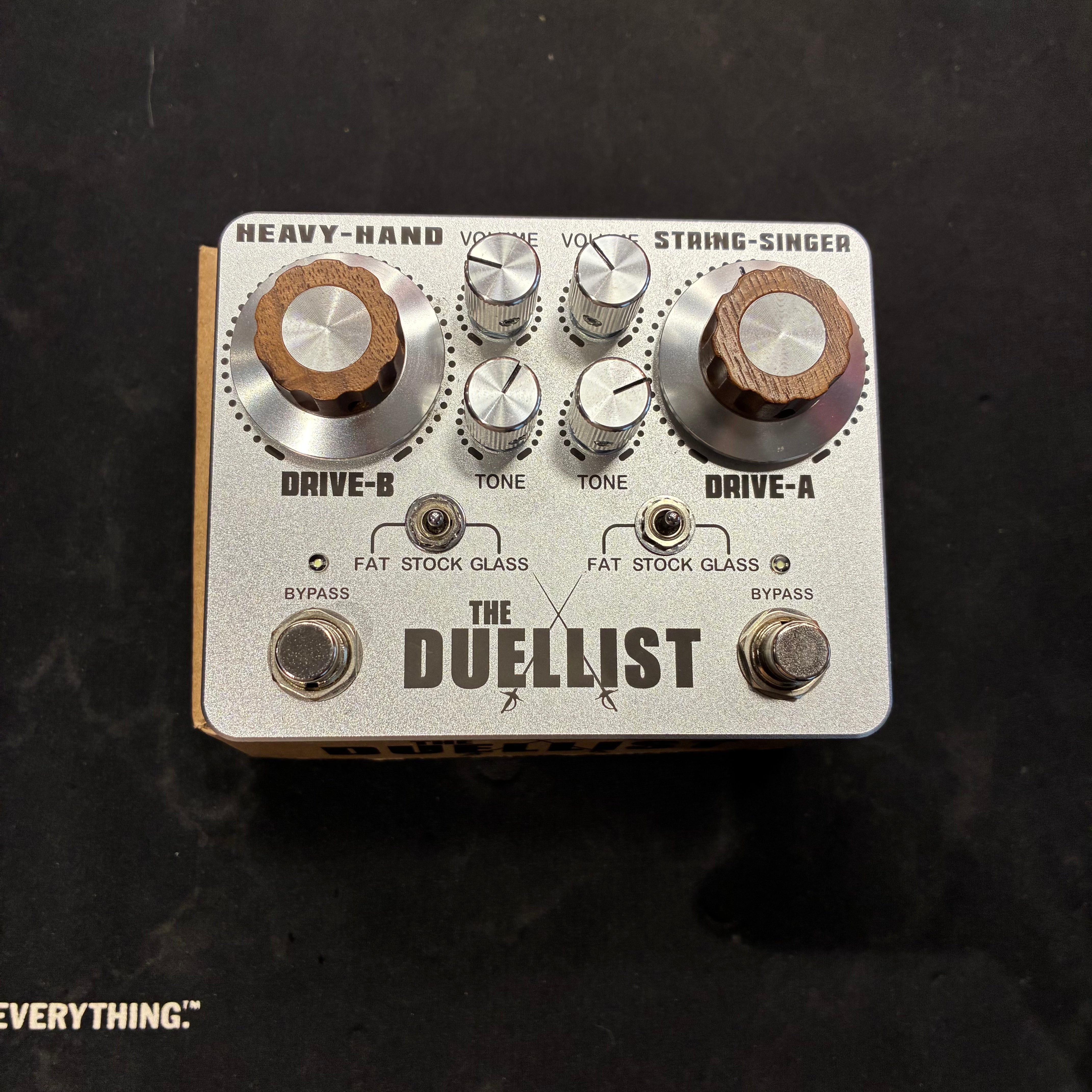 The Duellist FX pedal has six knobs, two toggle switches, and two footswitches on a silver metal enclosure labeled Drive-A and Drive-B.