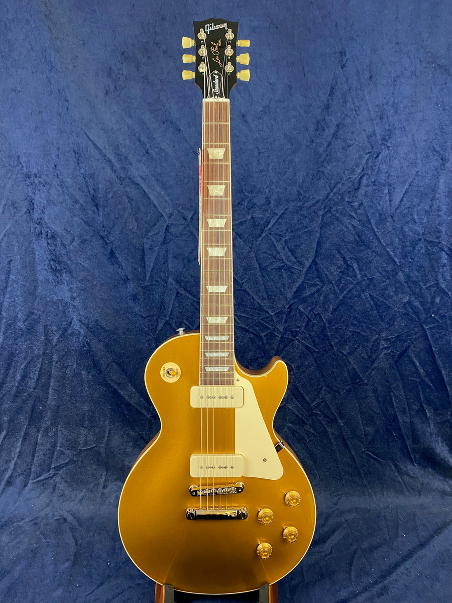 Gibson Les Paul electric guitar in metallic gold finish with cream pickguard, two pickups, four control knobs, and pearloid inlays on the fretboard.