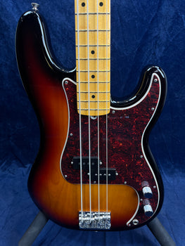 Sunburst finish bass guitar with a maple fretboard, black pickguard with red pattern, four strings, two control knobs, and chrome bridge hardware.