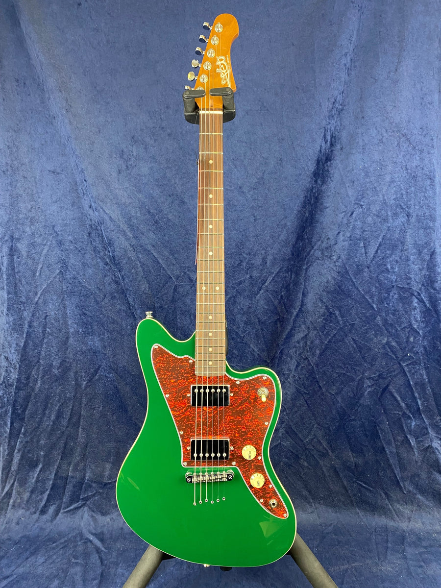 Electric guitar with a bright green offset body, tortoiseshell pickguard, two black pickups, two control knobs, and a light brown neck and headstock.