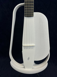 Modern white electric guitar with a minimalist, open-frame body design and a perforated panel below the strings for built-in speaker functionality.