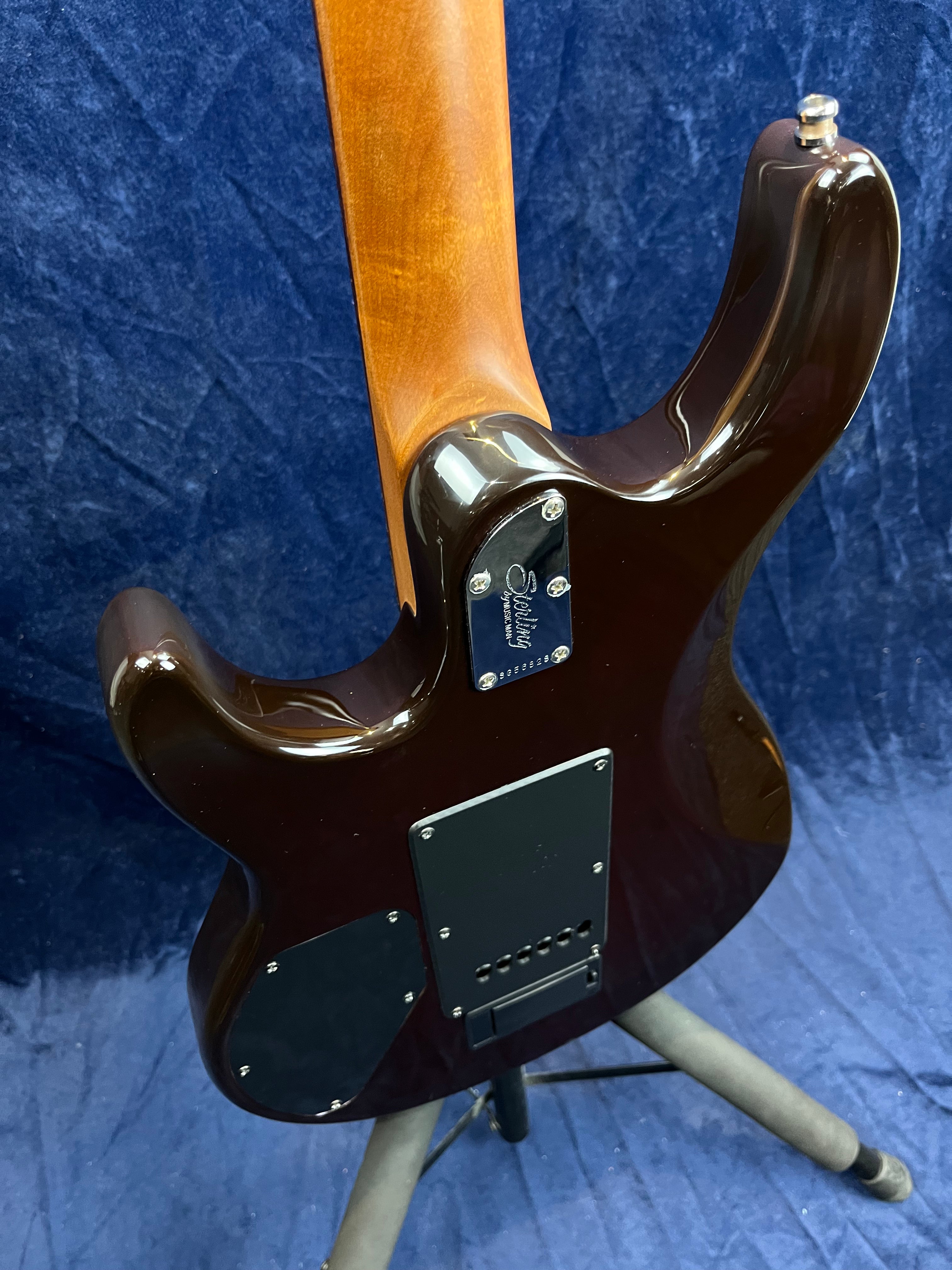Electric guitar rear view showing a glossy dark brown contoured body, natural wood neck, two black access panels, and a four-bolt neck plate.