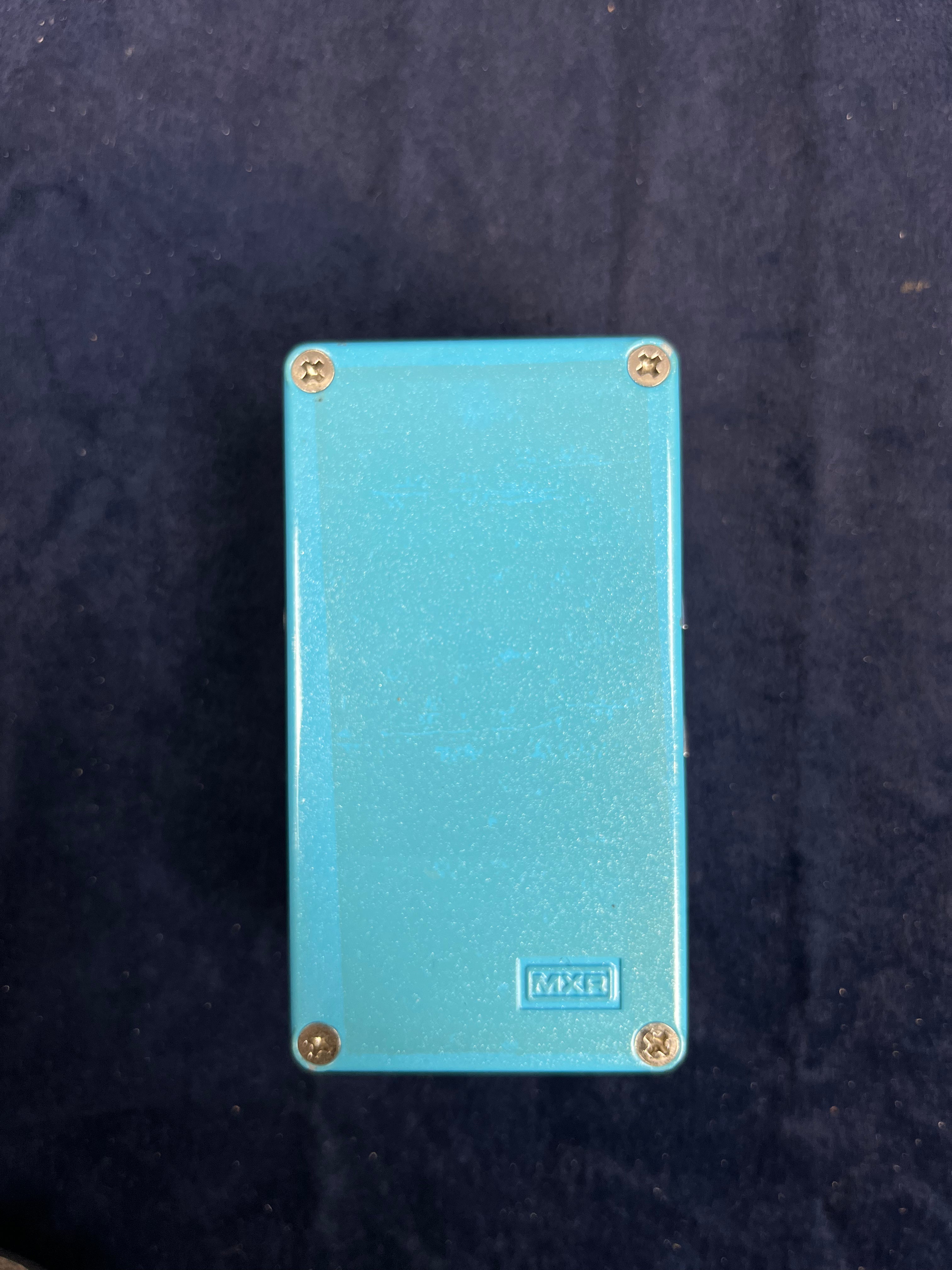 Rectangular MXR FX pedal, light blue, with four silver screws at each corner and no visible buttons or labels on the surface.