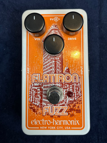 Electro-Harmonix Flatiron Fuzz FX pedal with three knobs labeled Vol, Drive, Filter, a footswitch, and an illustration of the Flatiron Building.