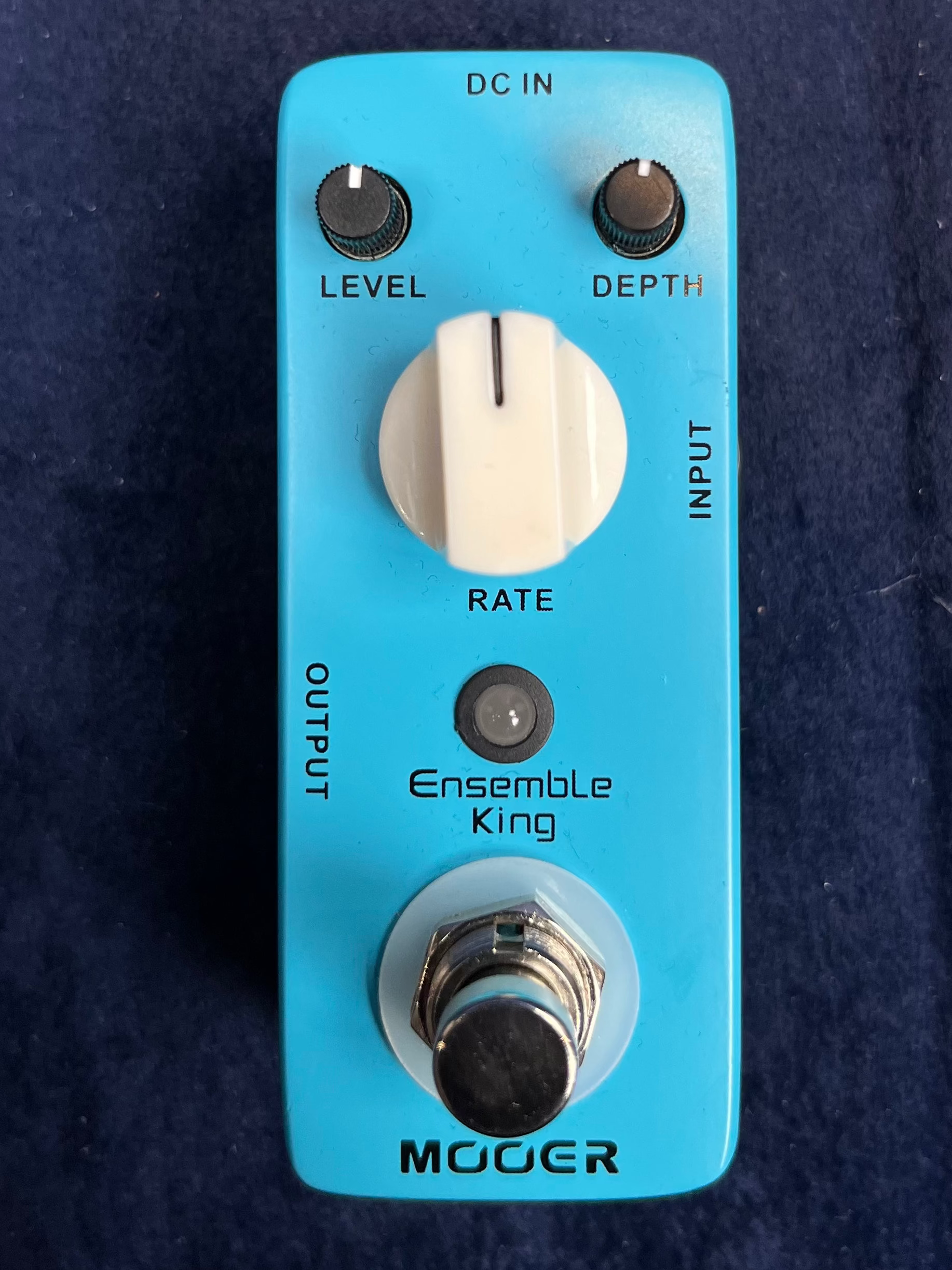 Pédale d’effet bleue Mooer Ensemble King avec trois boutons : Level, Depth, Rate, un interrupteur au pied et prises Input/Output.