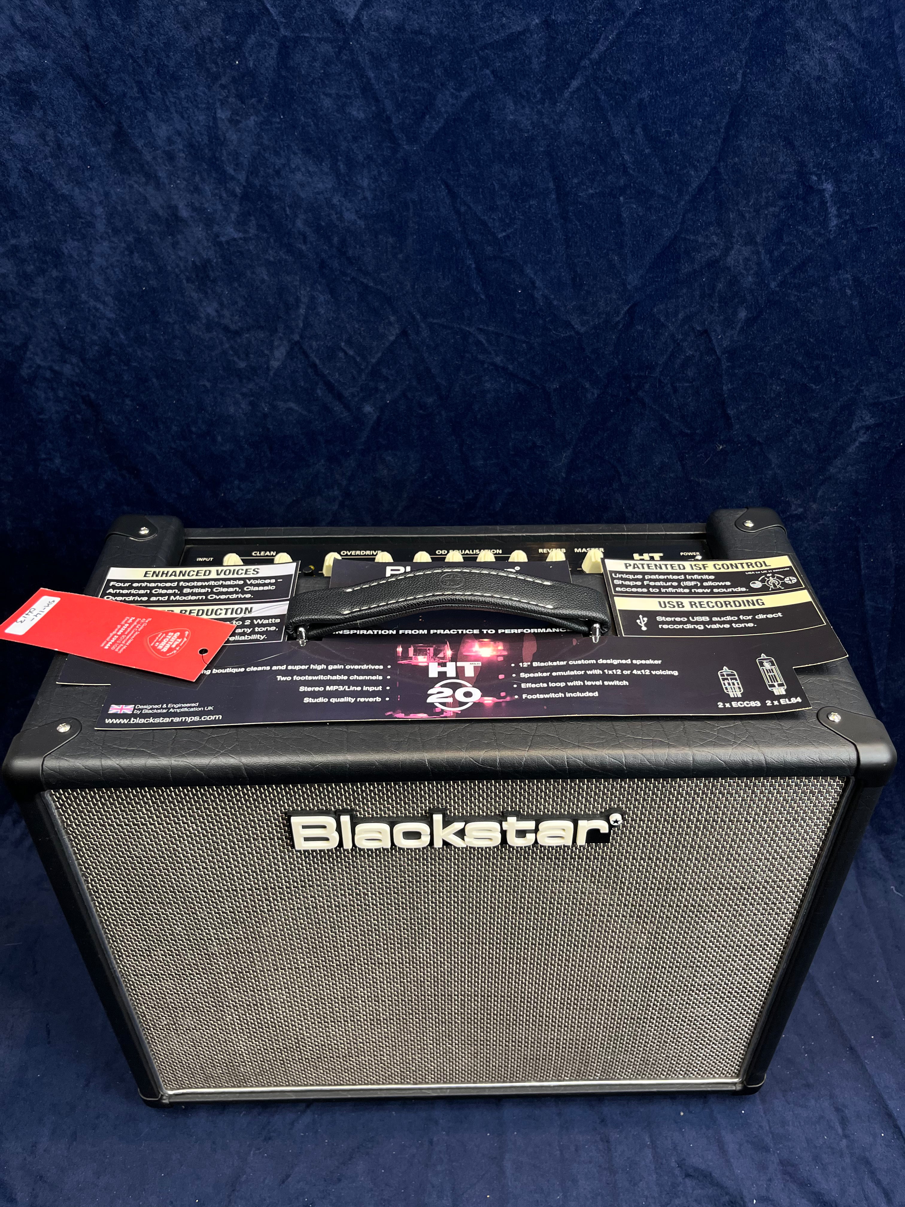 Blackstar guitar amplifier HT-20 model, black casing, silver mesh front, control knobs on top, and a handle with tagged information attached.