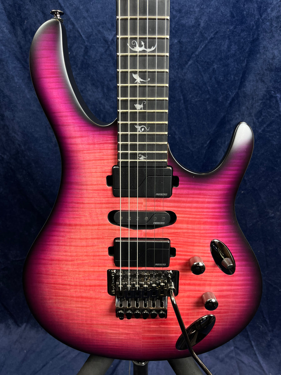 Electric guitar with a pink-to-purple burst finish, three pickups, bird inlays on the fretboard, and a locking tremolo bridge with whammy bar.
