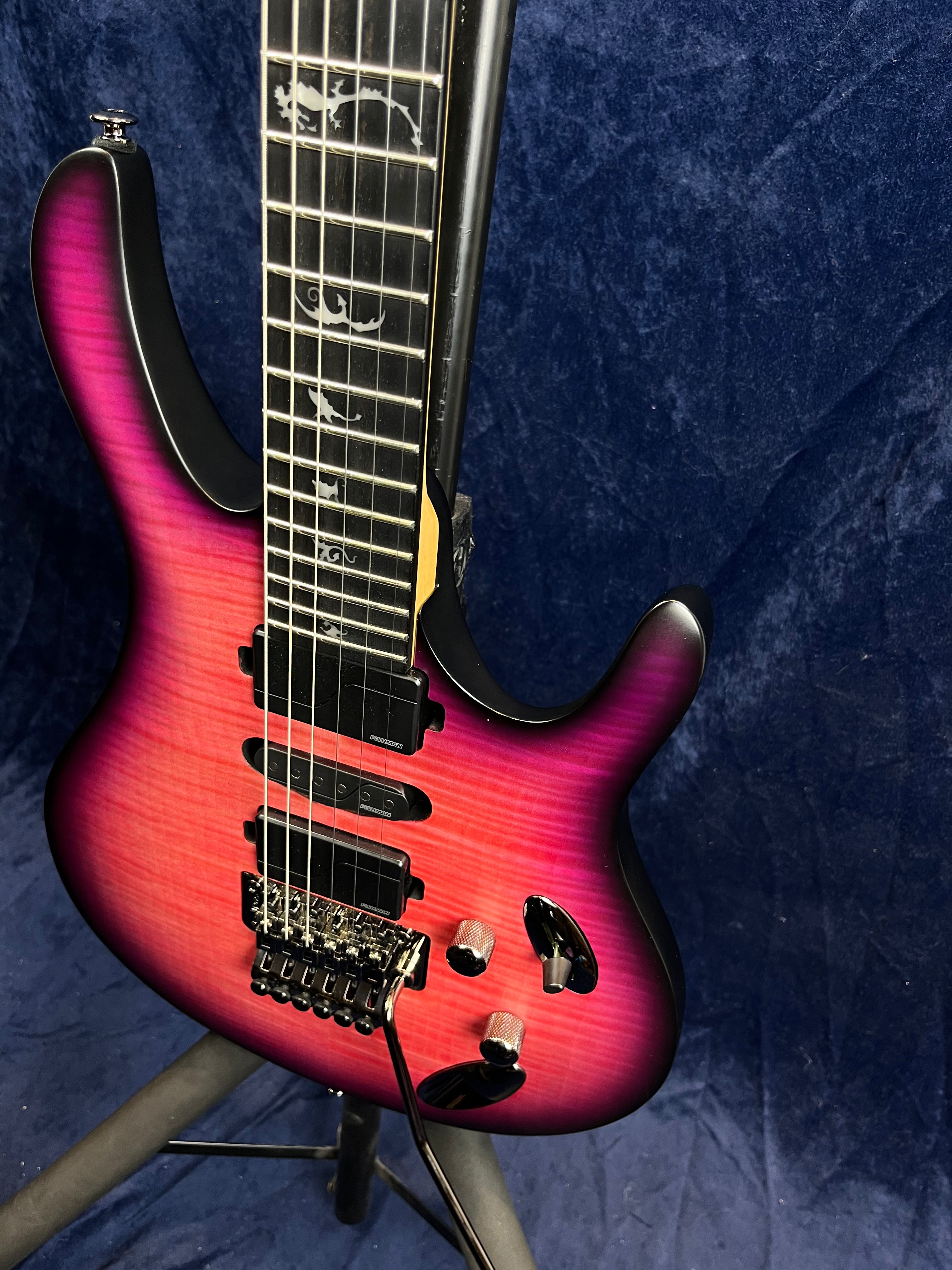 Electric guitar with a pink and purple sunburst finish, three pickups, a locking tremolo bridge, and dragon inlays on a dark fretboard.