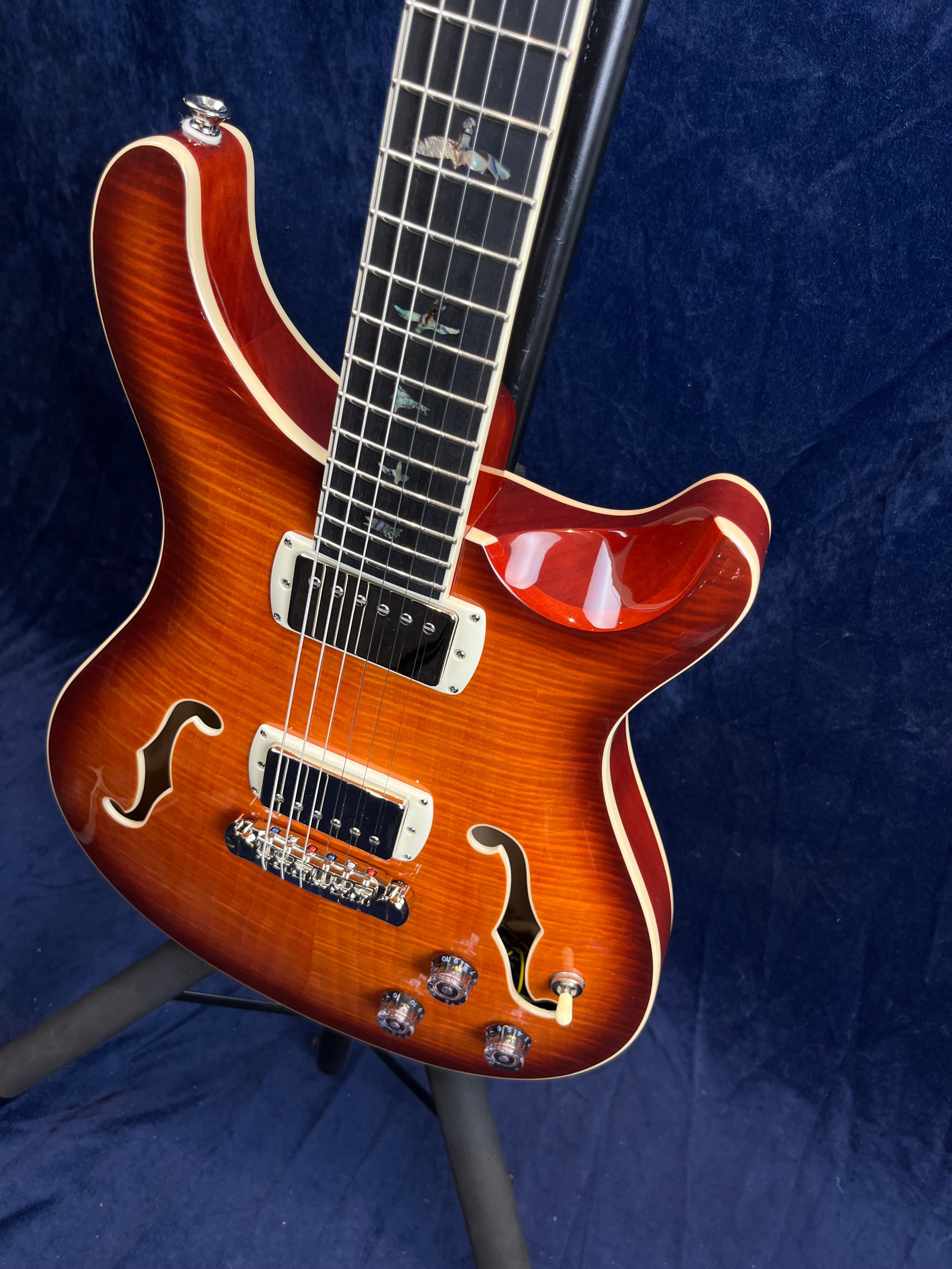 Sunburst semi-hollow electric guitar with two humbucker pickups, f-holes, four knobs, cream binding, and bird inlays on the fretboard.