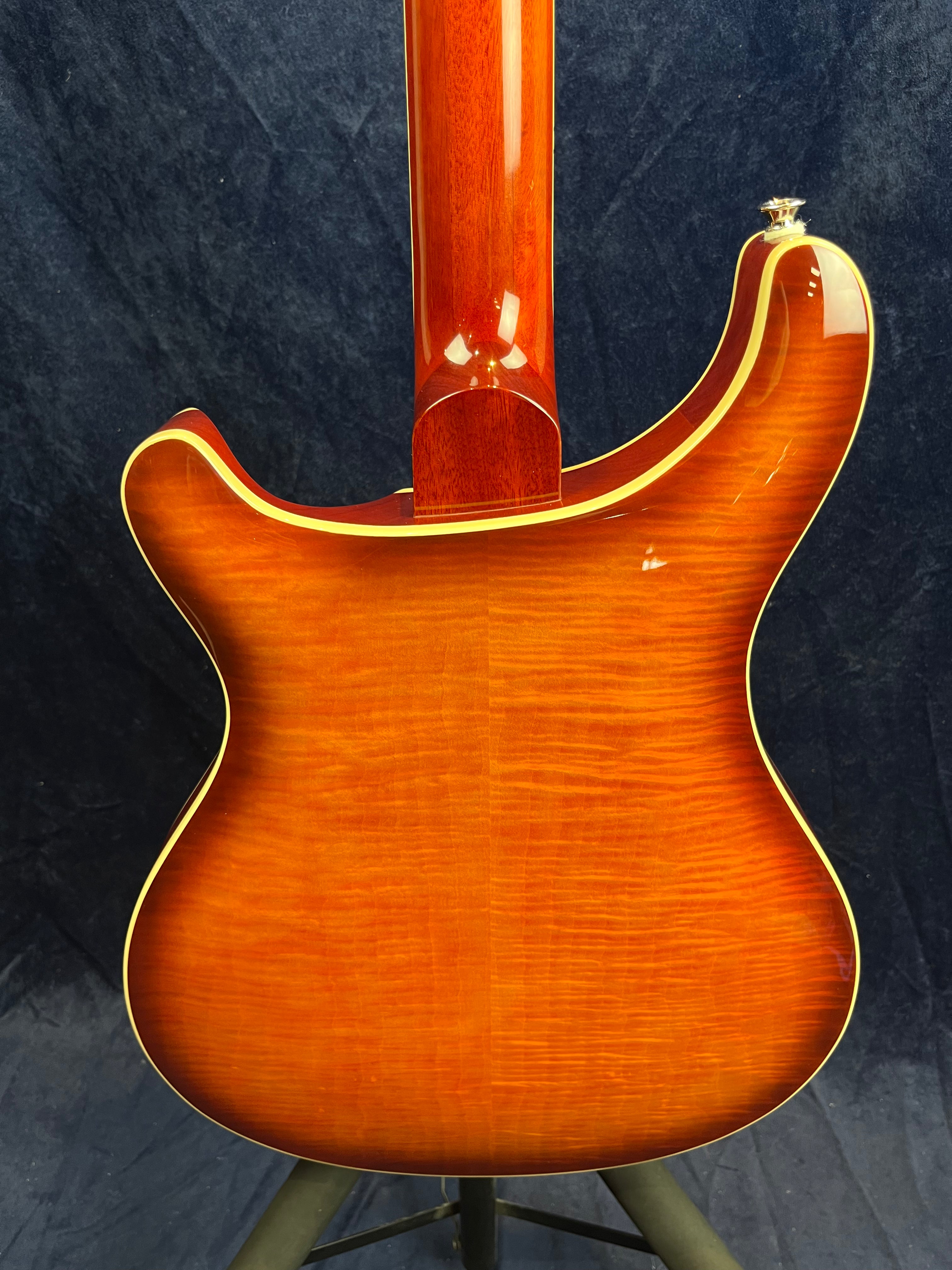 Electric guitar back in glossy sunburst finish with flame maple wood grain and cream binding, shown from the neck joint down to the body.