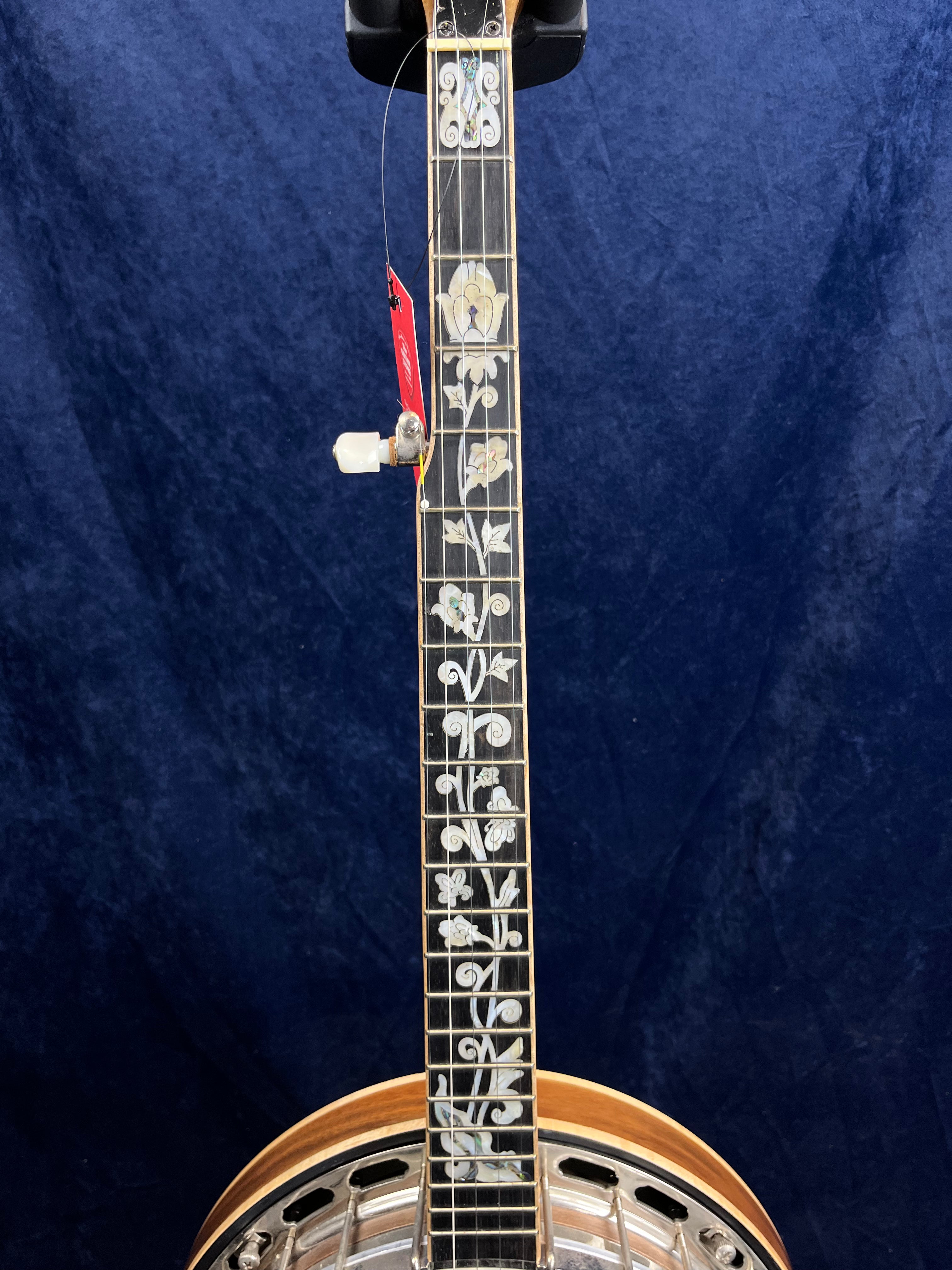 Manche de banjo orné d’incrustations florales nacrées sur toute la touche, avec une mécanique banjo blanche sur le côté.