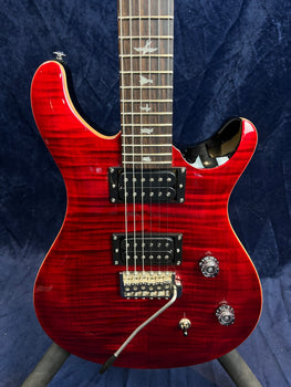 Glossy red electric guitar with two humbucker pickups, whammy bar, three control knobs, and bird-shaped inlays on a rosewood fretboard.