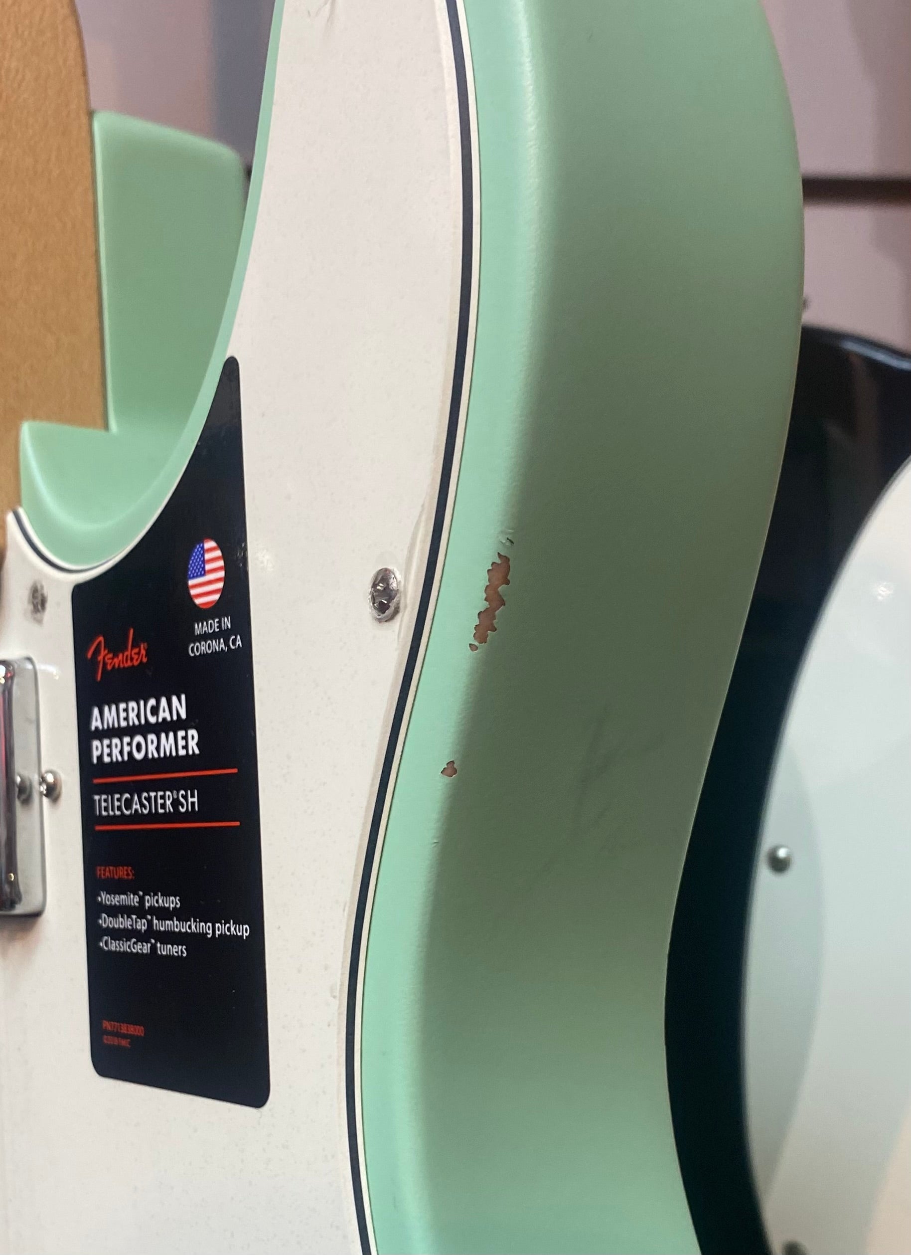Fender American Performer Telecaster SH electric guitar with a chipped area exposing wood on its green edge near the body contour.