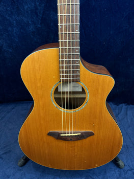 Brown acoustic guitar with a natural wood finish, cutaway body, six strings, and decorative inlay around the soundhole.