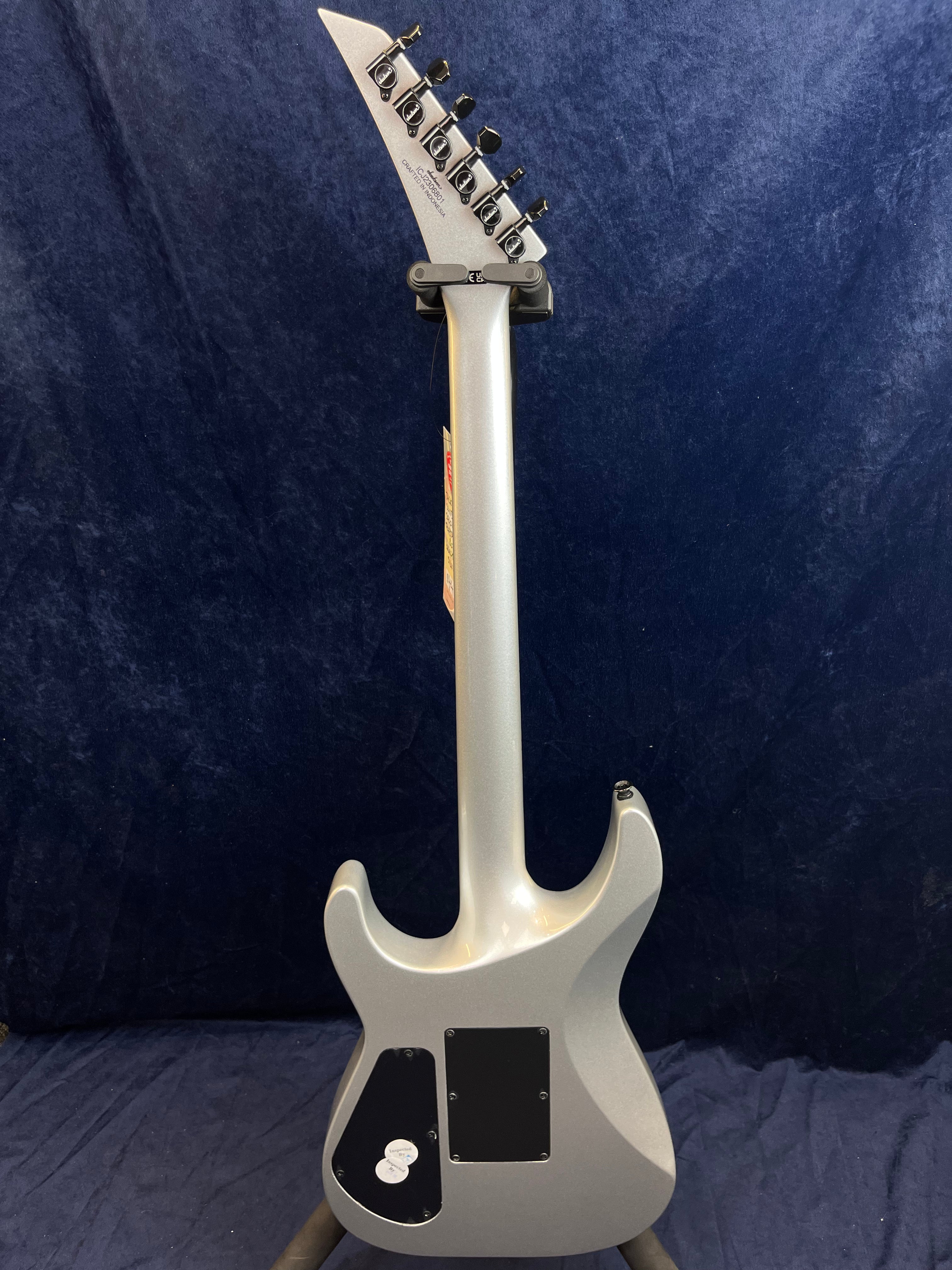Guitare électrique argentée vue de dos, tête inclinée, six mécaniques noires, deux trappes noires pour l’électronique sur le corps.