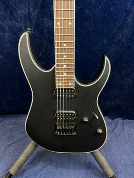 Matte black electric guitar with two humbucker pickups, two control knobs, a whammy bar, and a rosewood fretboard with dot inlays.