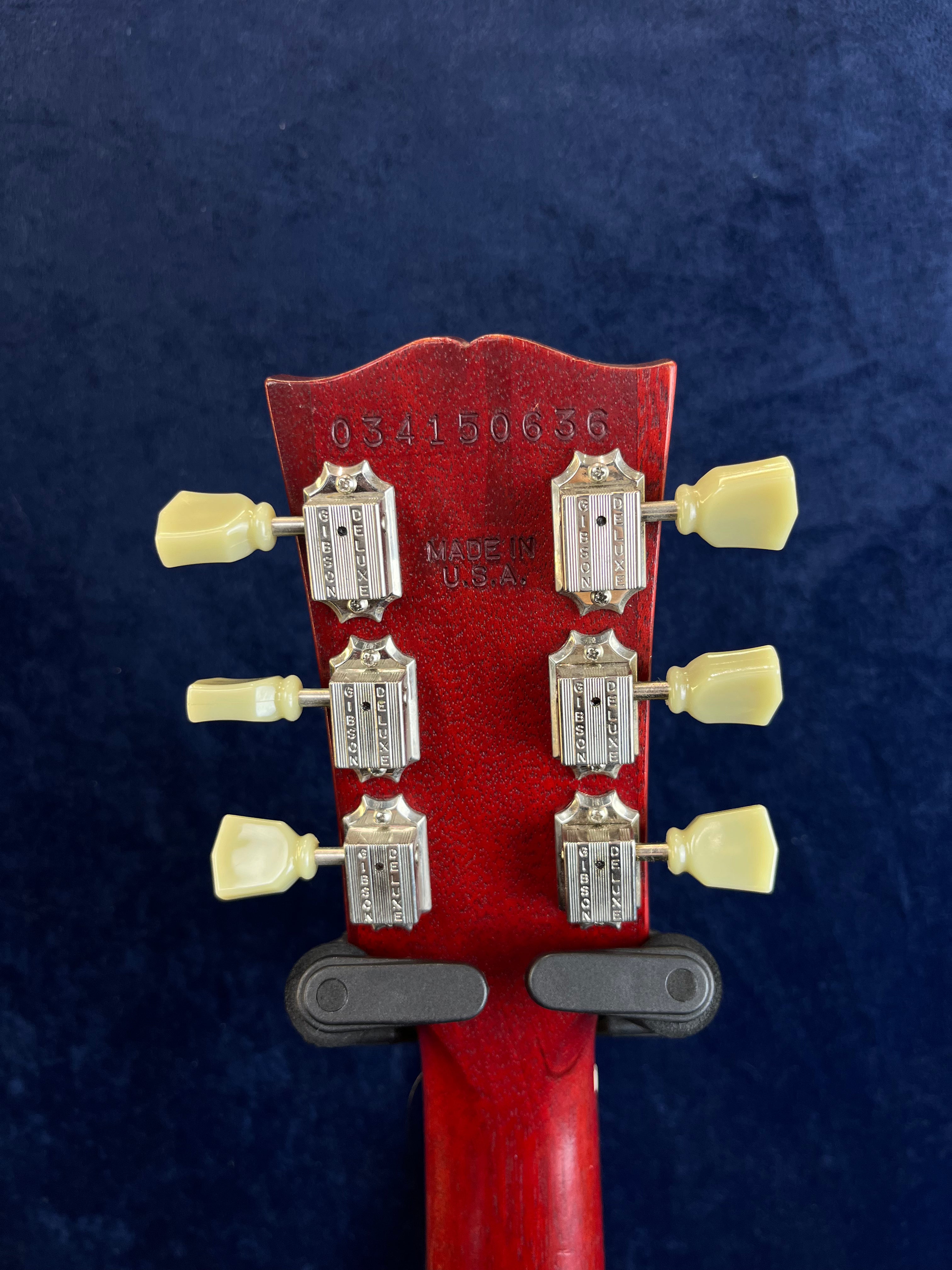 Back of a red electric guitar headstock showing six vintage-style Gibson tuners, serial number 034150636, and “Made in U.S.A.” stamped in the wood.