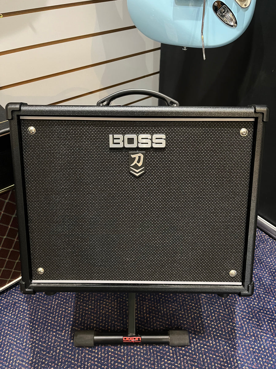 Black Boss guitar amplifier with a textured front panel, silver Boss logo, carry handle on top, and sitting on a Dixon stand.