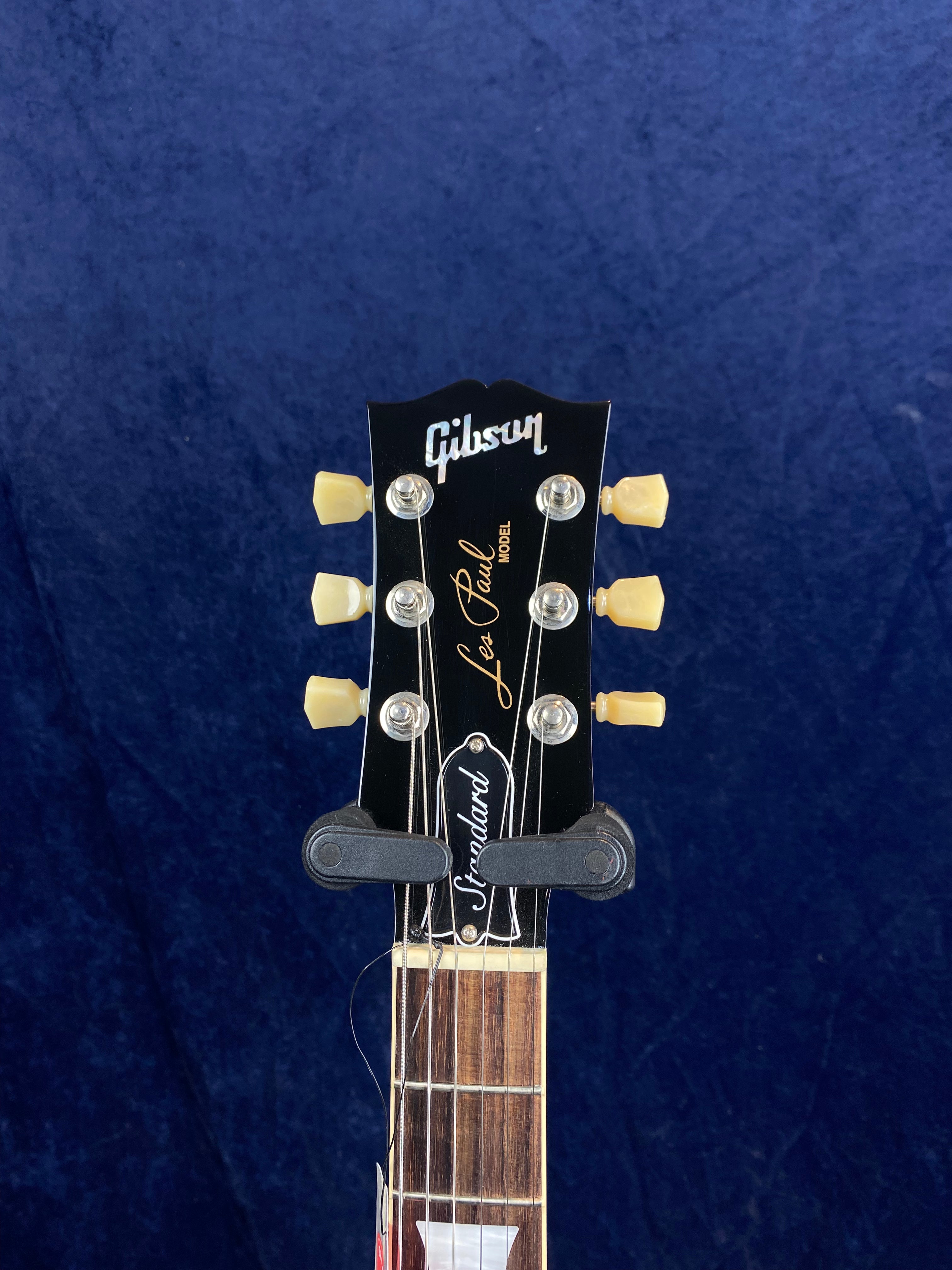 Gibson Les Paul Standard electric guitar headstock with six cream tuning pegs, truss rod cover labeled "Standard," and rosewood fretboard visible.
