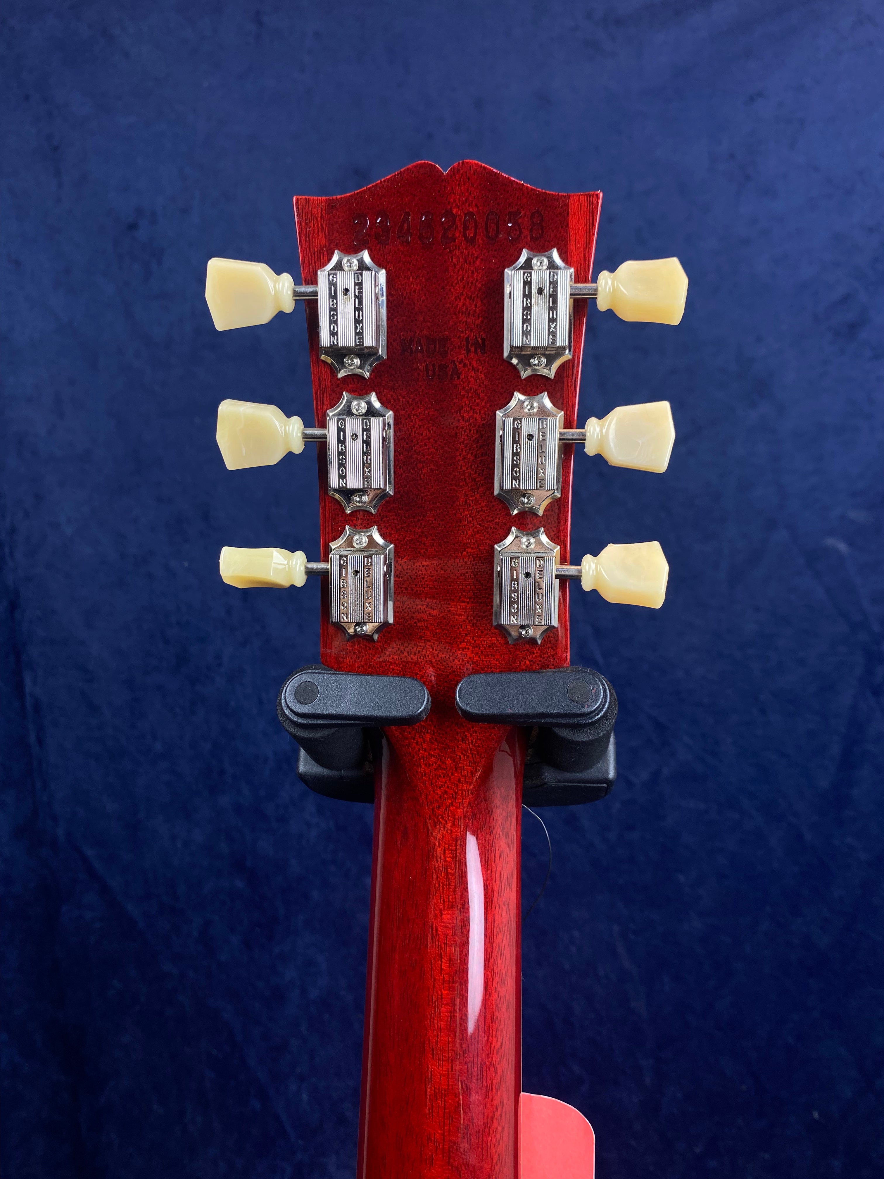 Red electric guitar headstock with six cream tuning pegs, silver tuners, and "MADE IN USA" stamped above the neck.