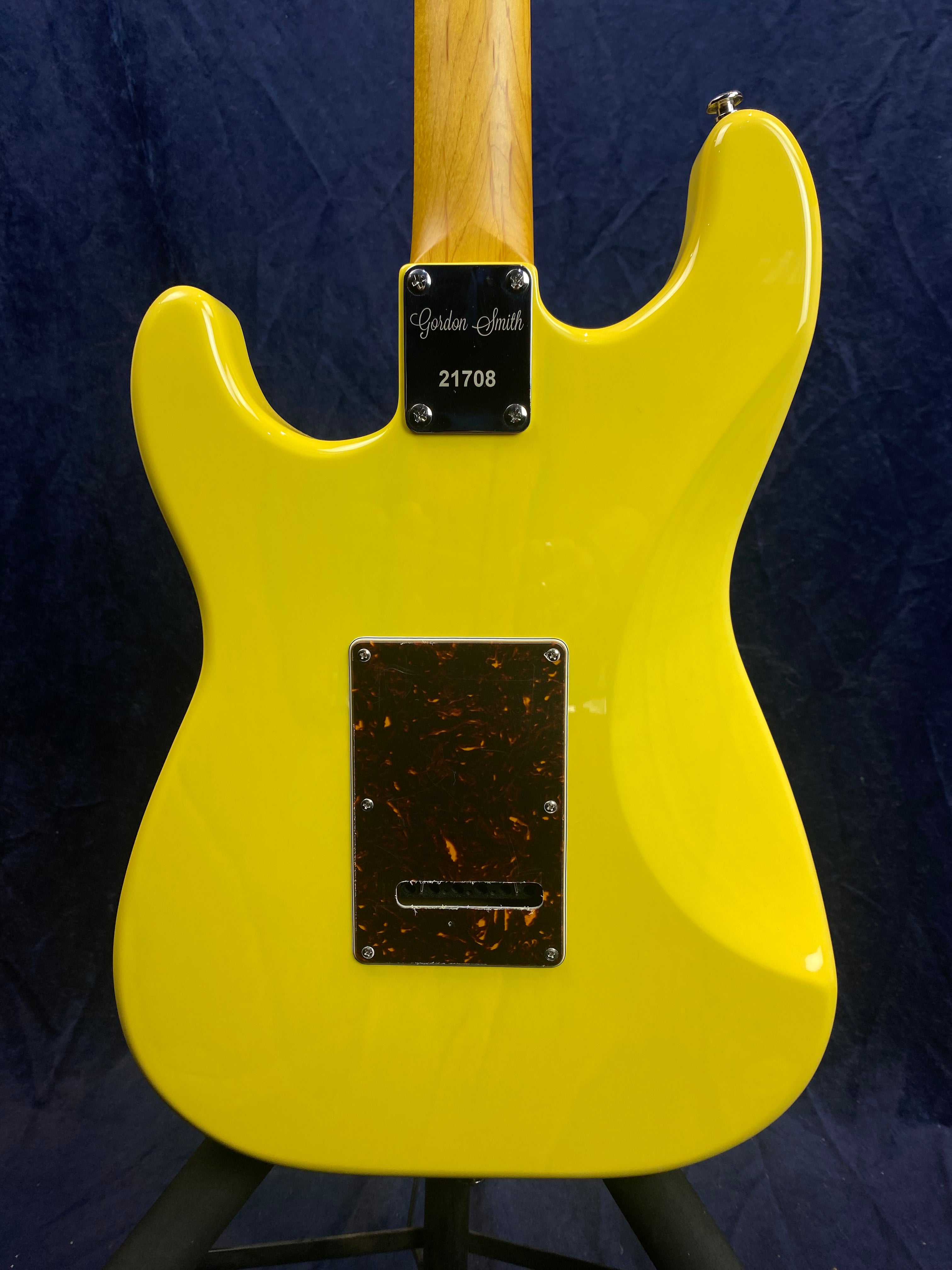 Bright yellow electric guitar back, maple neck, rectangular backplate, metal neck plate engraved with "Gordon Smith 21708."
