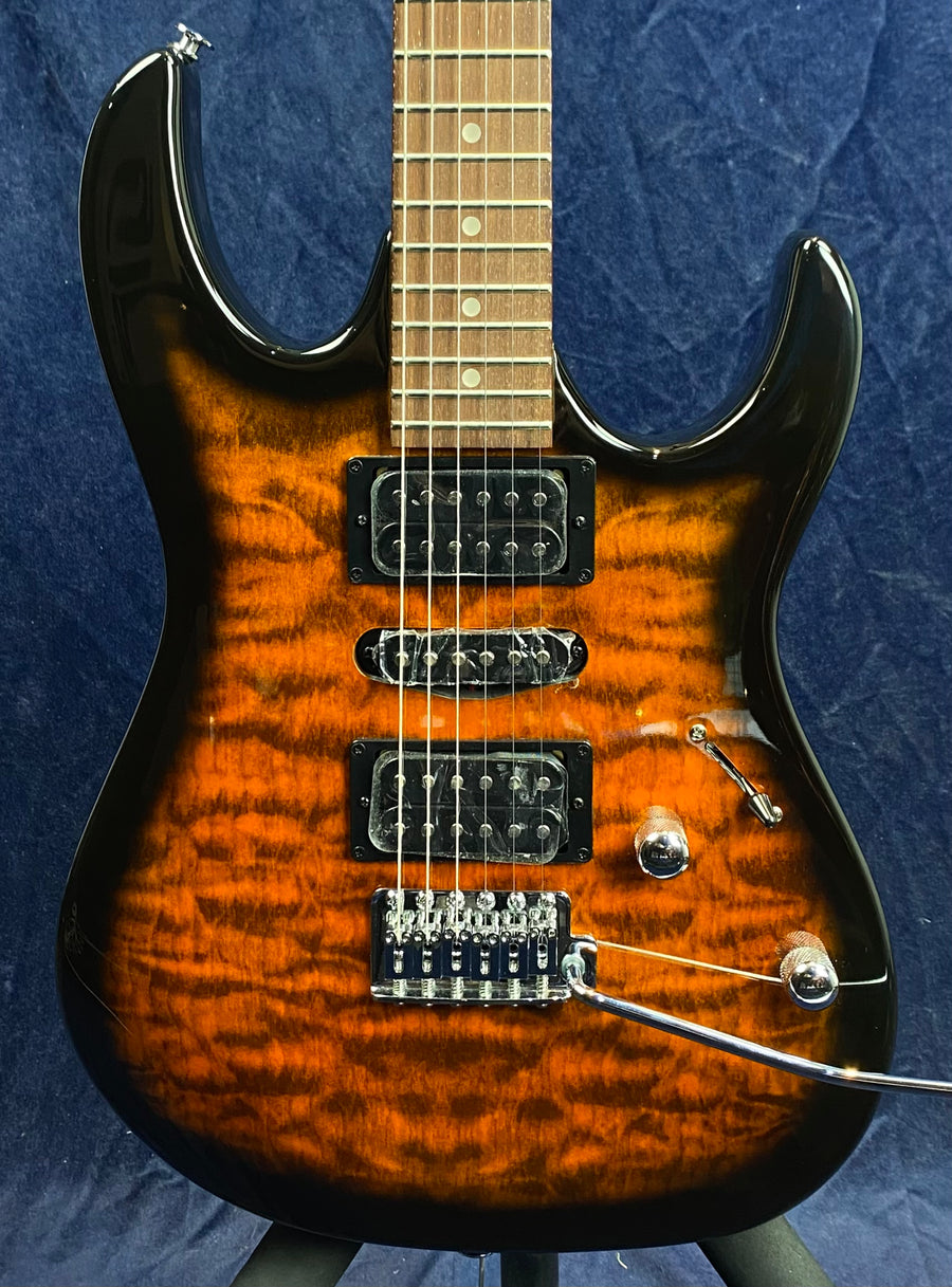 Electric guitar with a glossy amber tiger-stripe finish, three pickups, two control knobs, a pickup switch, and a chrome tremolo bridge.