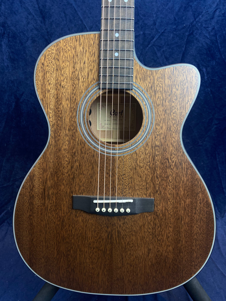 A cutaway acoustic guitar with a dark natural wood finish, six strings, a circular sound hole, and white dot fret markers on a rosewood fingerboard.