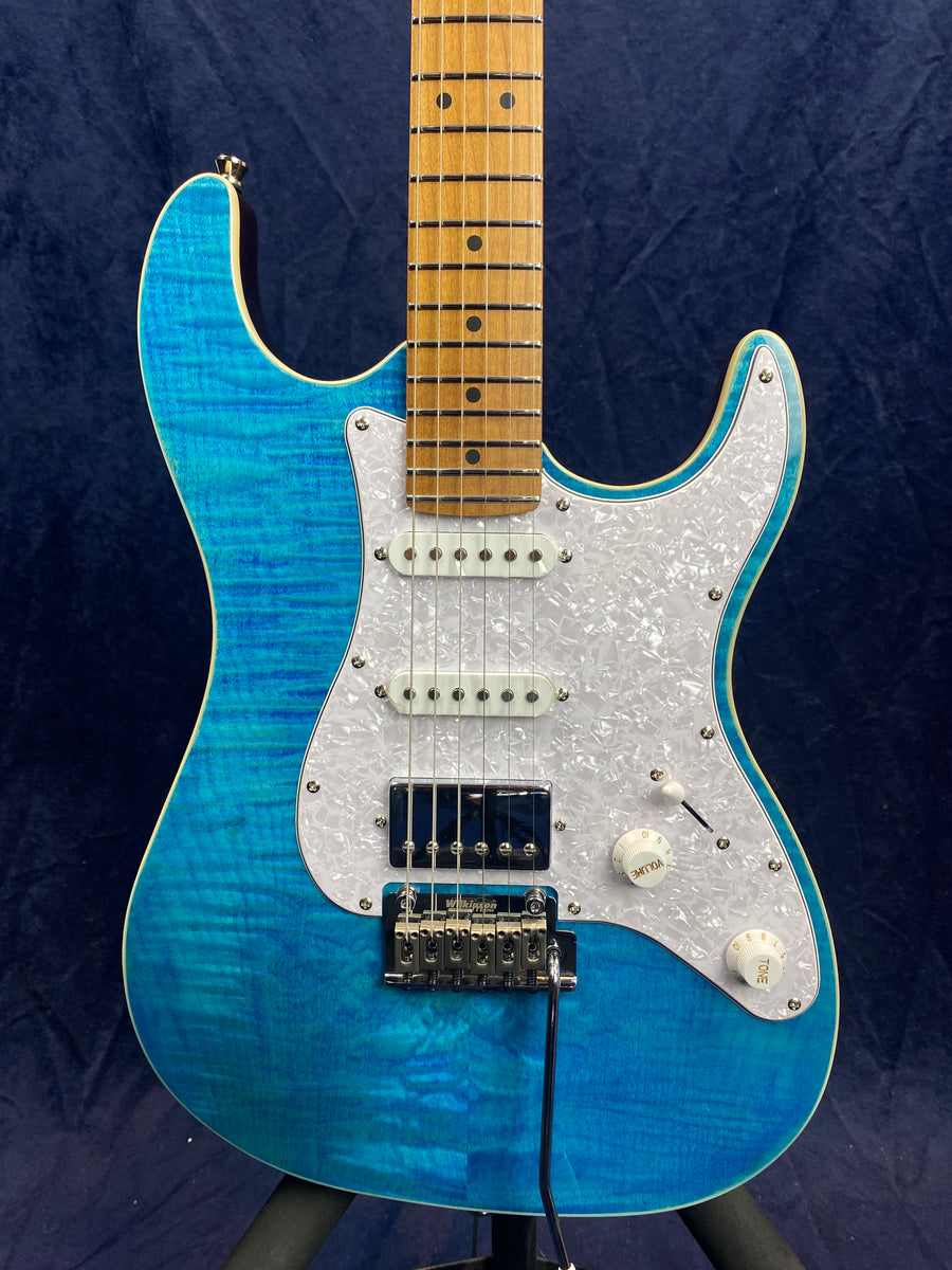 Bright blue electric guitar with white pearloid pickguard, two single coil pickups, one humbucker pickup, and maple fretboard.
