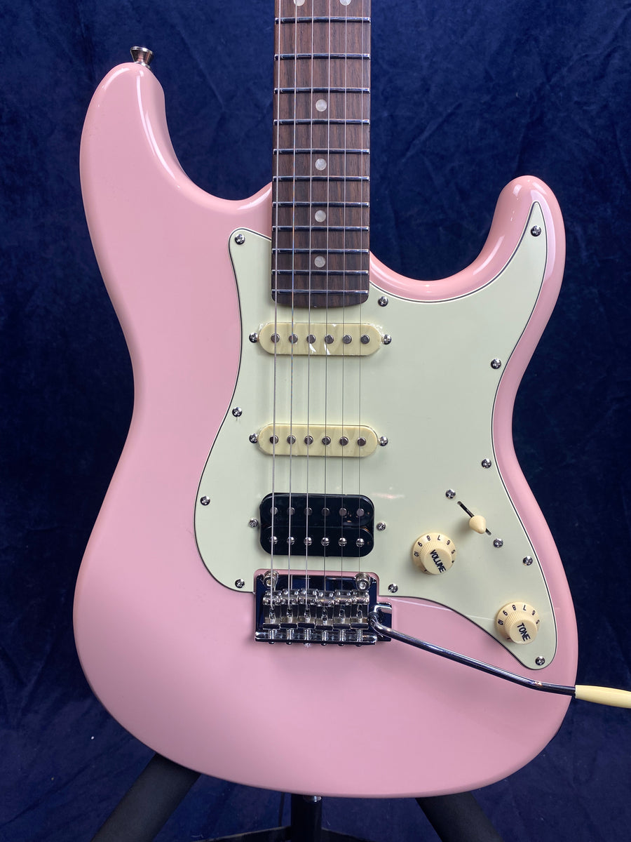 Electric guitar with a light pink body, white pickguard, two cream single-coil pickups, one black humbucker, and three cream control knobs.
