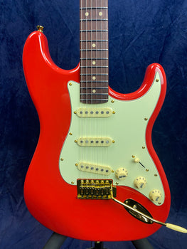 Jet electric guitar in glossy red with a white pickguard, three single-coil pickups, gold bridge, and control knobs for volume and tone.