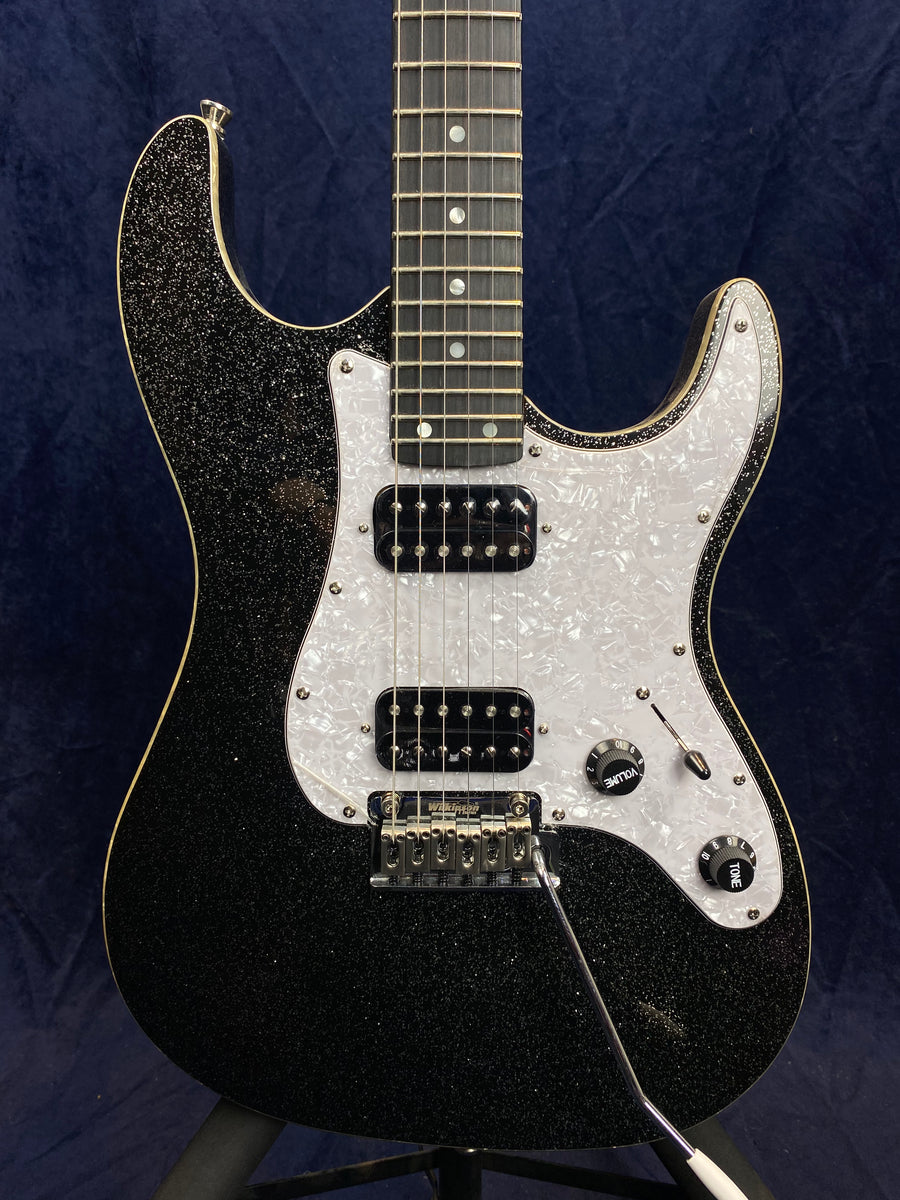 Black sparkle electric guitar with white pearloid pickguard, two humbucker pickups, chrome tremolo bridge, and volume and tone knobs.