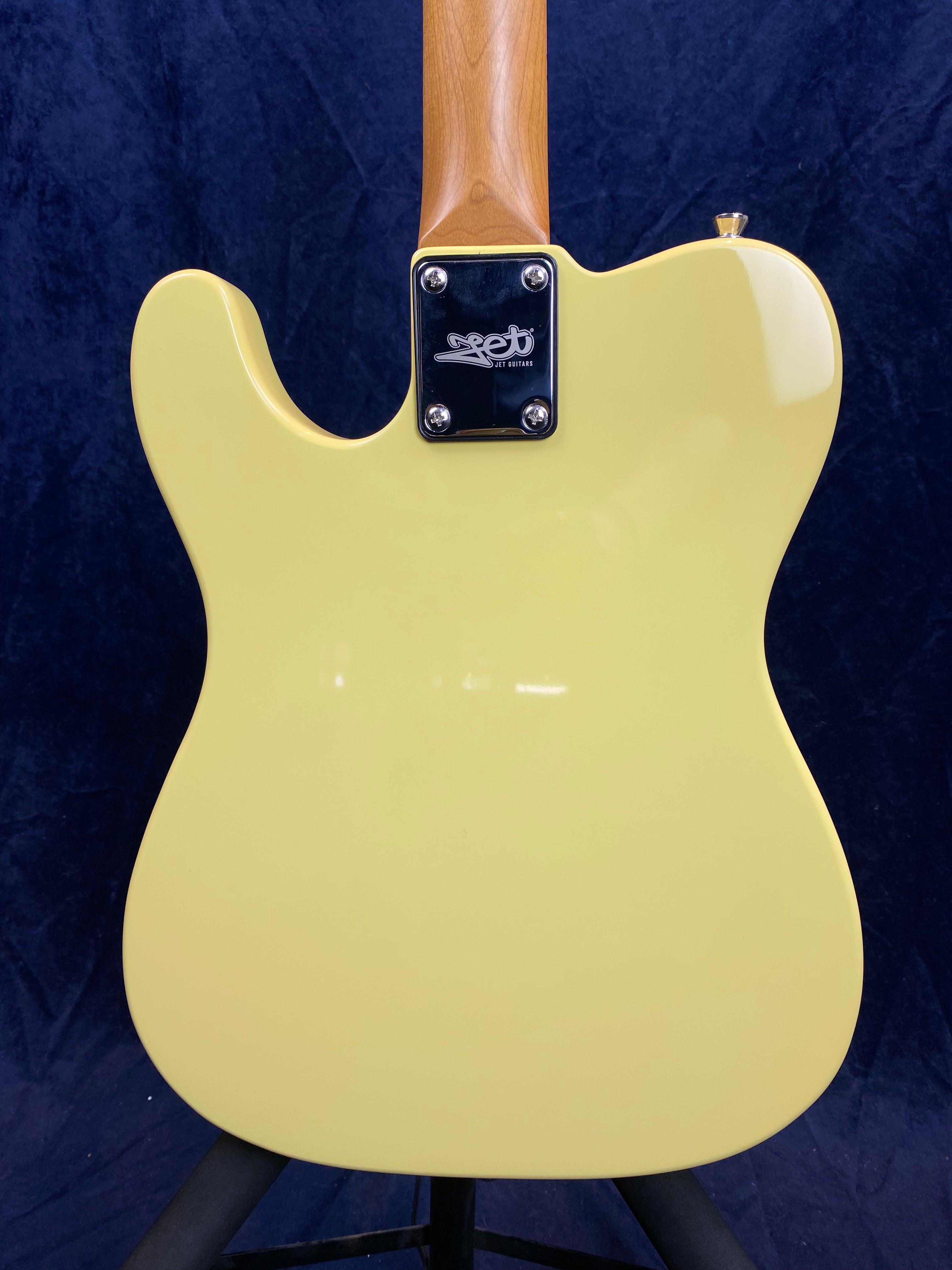 Pale yellow electric guitar body with a natural wood neck; metal neck plate reads "Set Guitars."