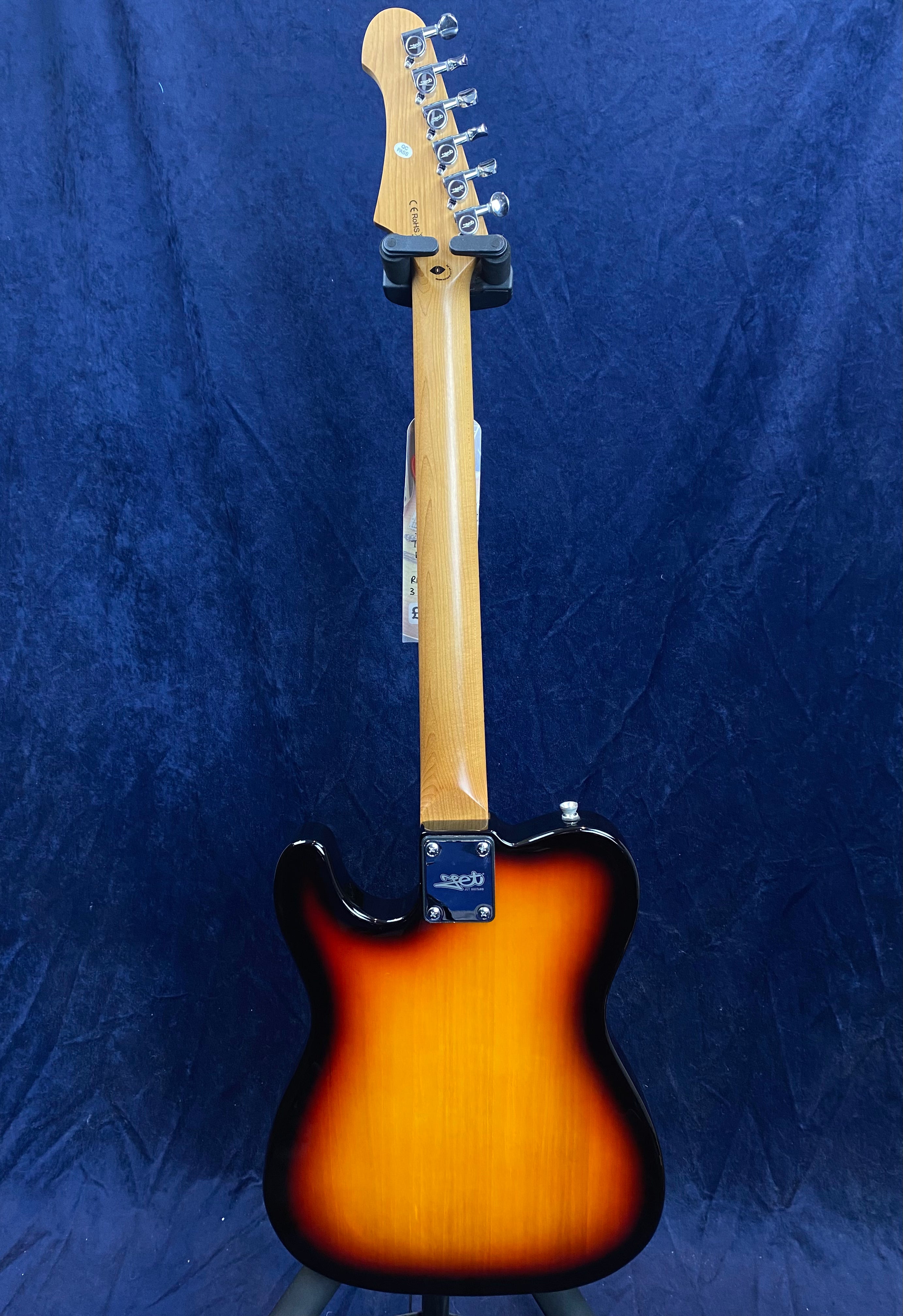 Sunburst electric guitar viewed from the back, showing a natural wood neck and tuning pegs, with a glossy yellow-to-black gradient body.
