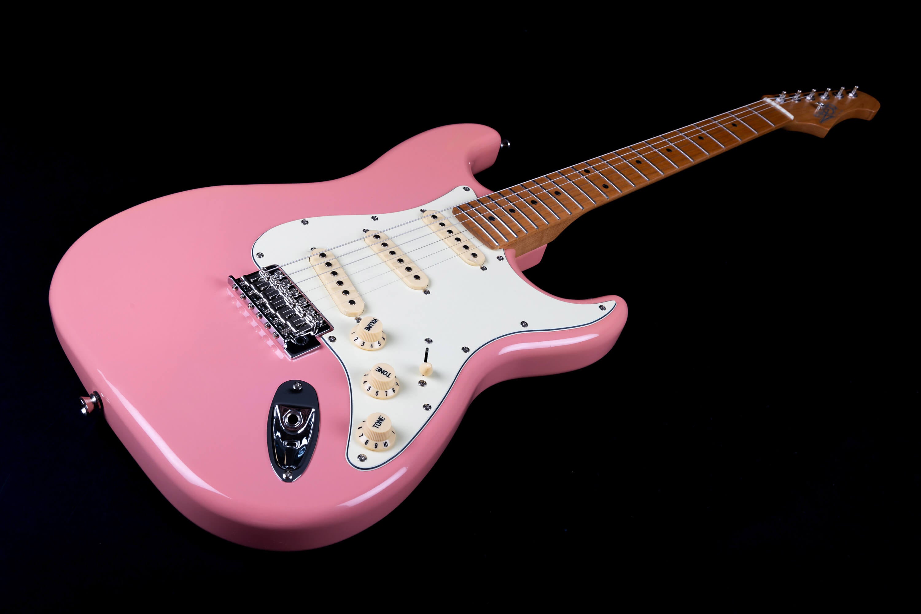 Electric guitar with a glossy pink body, white pickguard, three cream pickups, and a light brown neck, displayed against a black background.