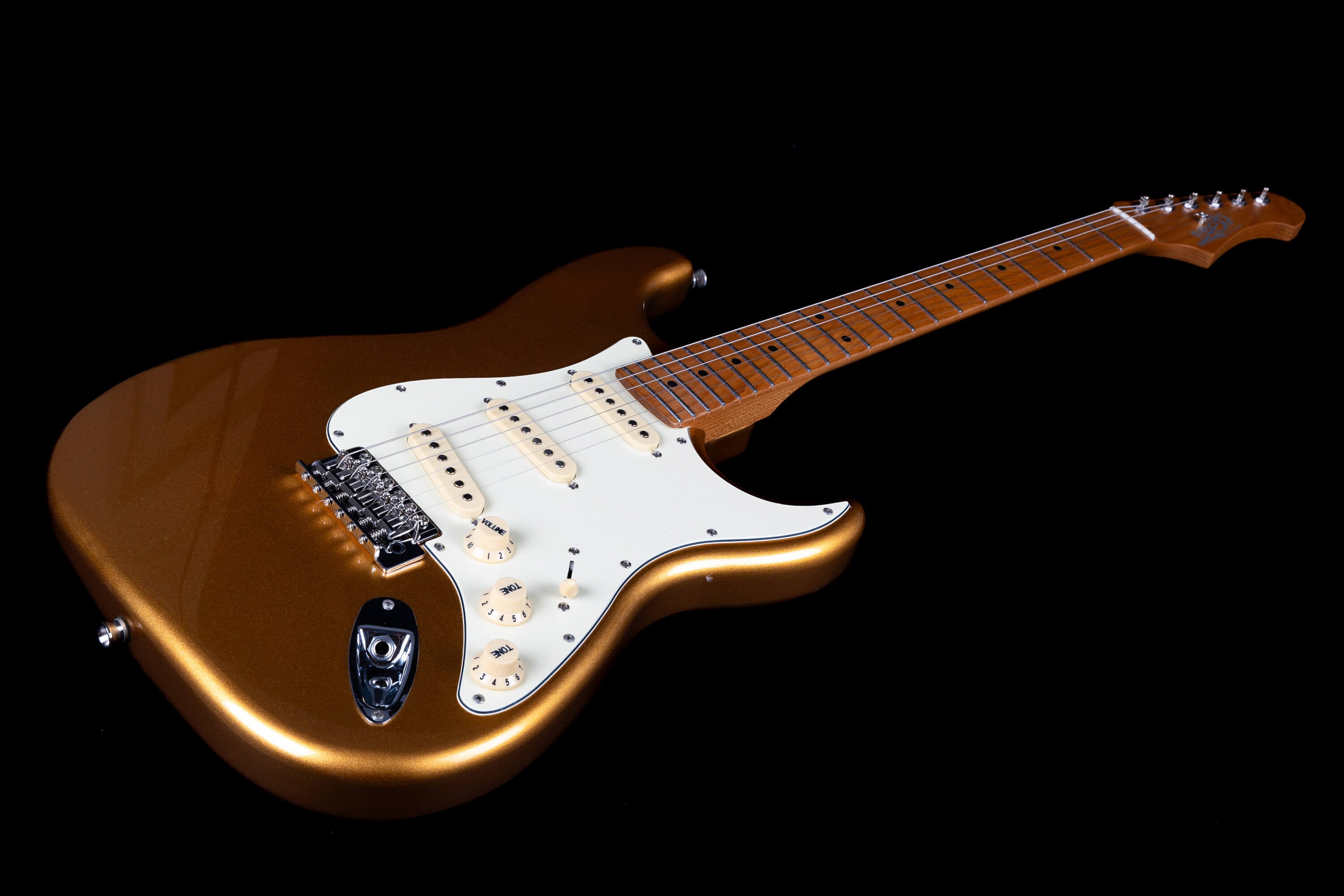 Metallic gold electric guitar with a white pickguard, three single-coil pickups, maple neck, and six tuning pegs on the headstock.