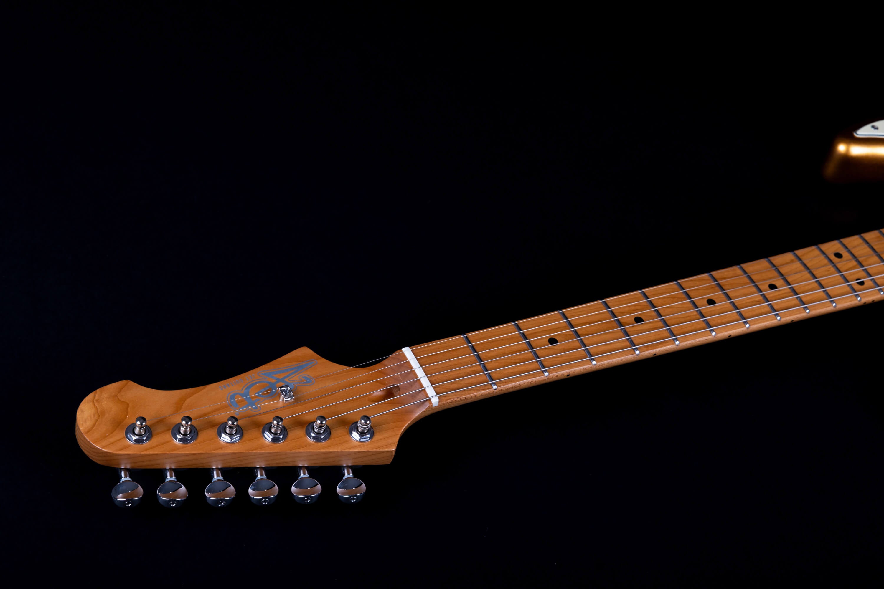 Light brown electric guitar neck and headstock with six tuning pegs, metal frets, and inlaid position dots on a black background.
