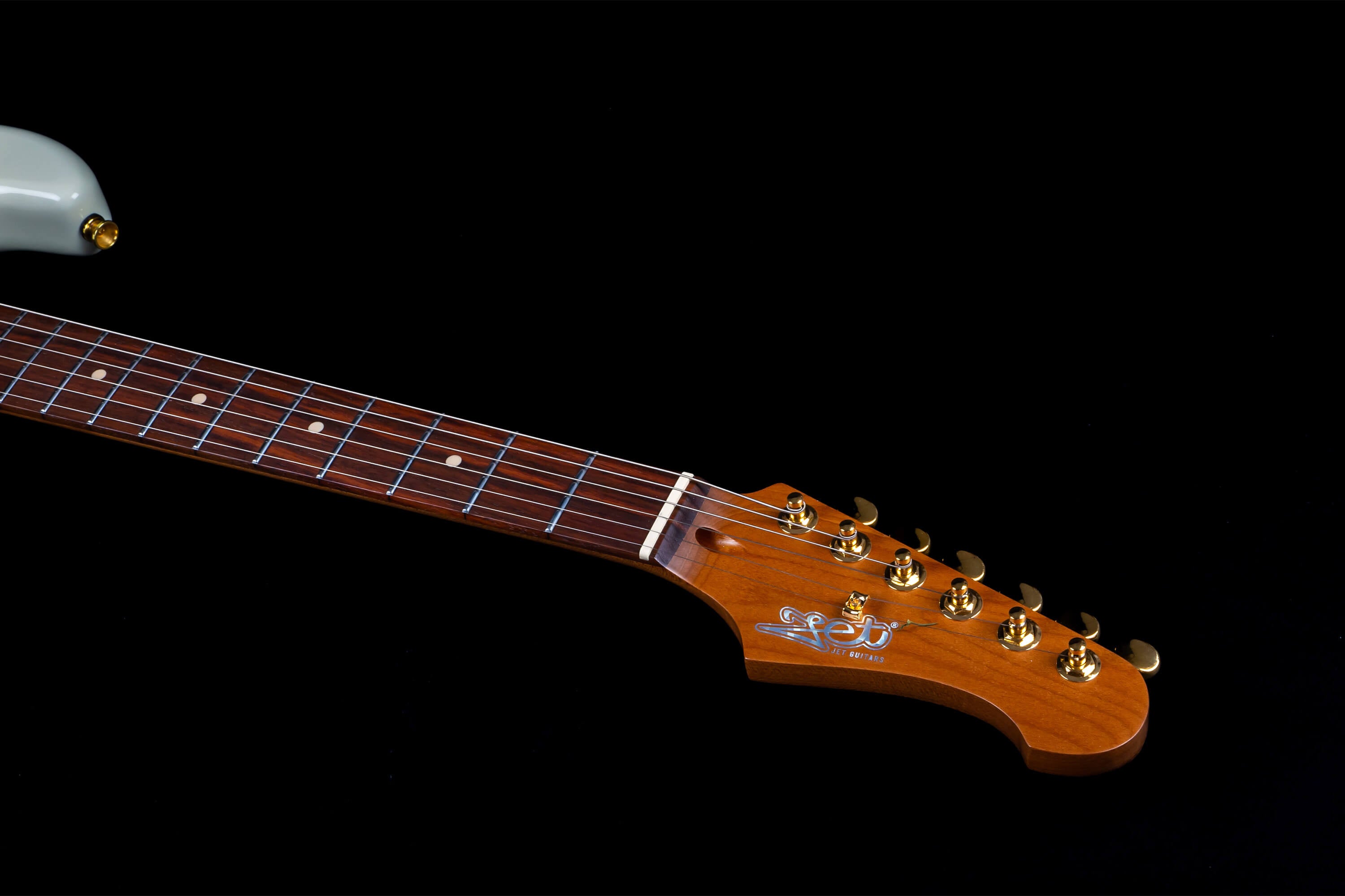 Electric guitar neck and headstock with six gold tuning pegs, rosewood fretboard, dot inlays, and visible brand logo on the headstock.