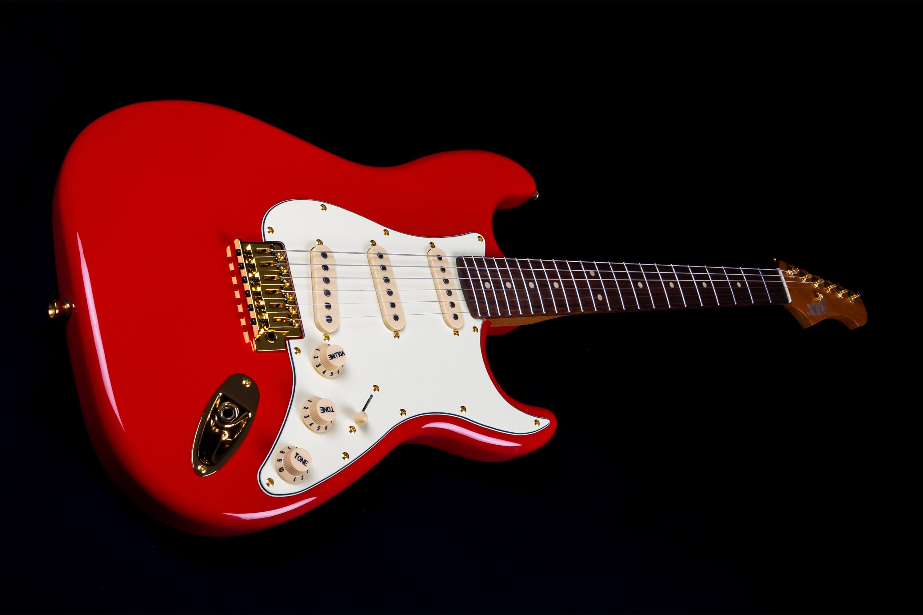 Bright red Jet electric guitar with a white pickguard, gold hardware, three single-coil pickups, and a dark fretboard on a black background.