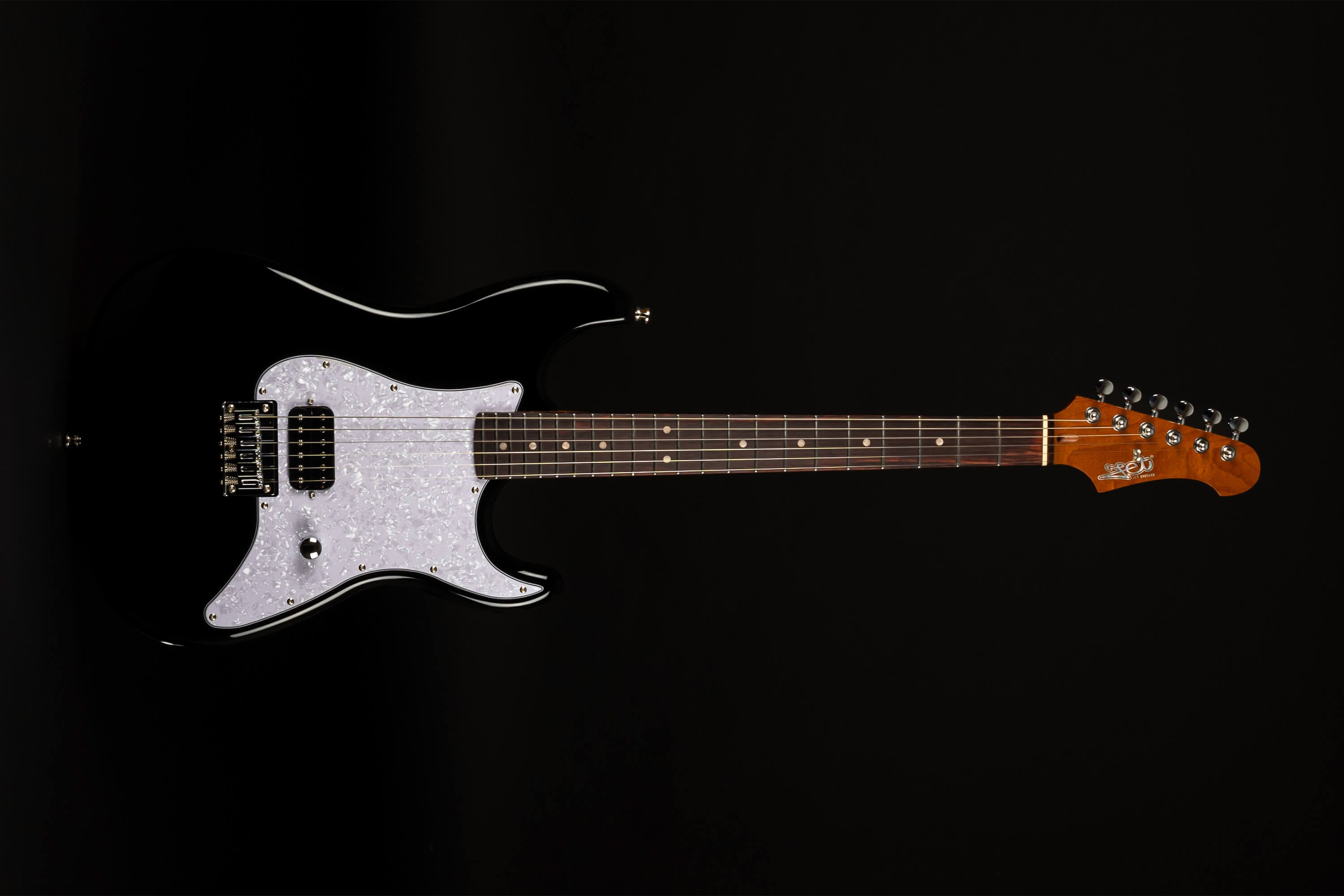 Black electric guitar with a glossy body, white pearloid pickguard, two humbucker pickups, rosewood fretboard, and natural wood headstock.