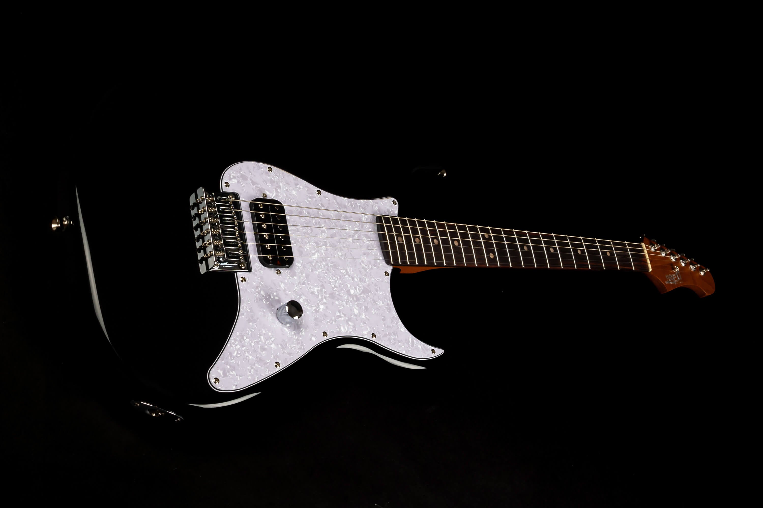 Glossy black electric guitar with a white pearloid pickguard, single humbucker pickup, chrome bridge, and dark wooden neck.