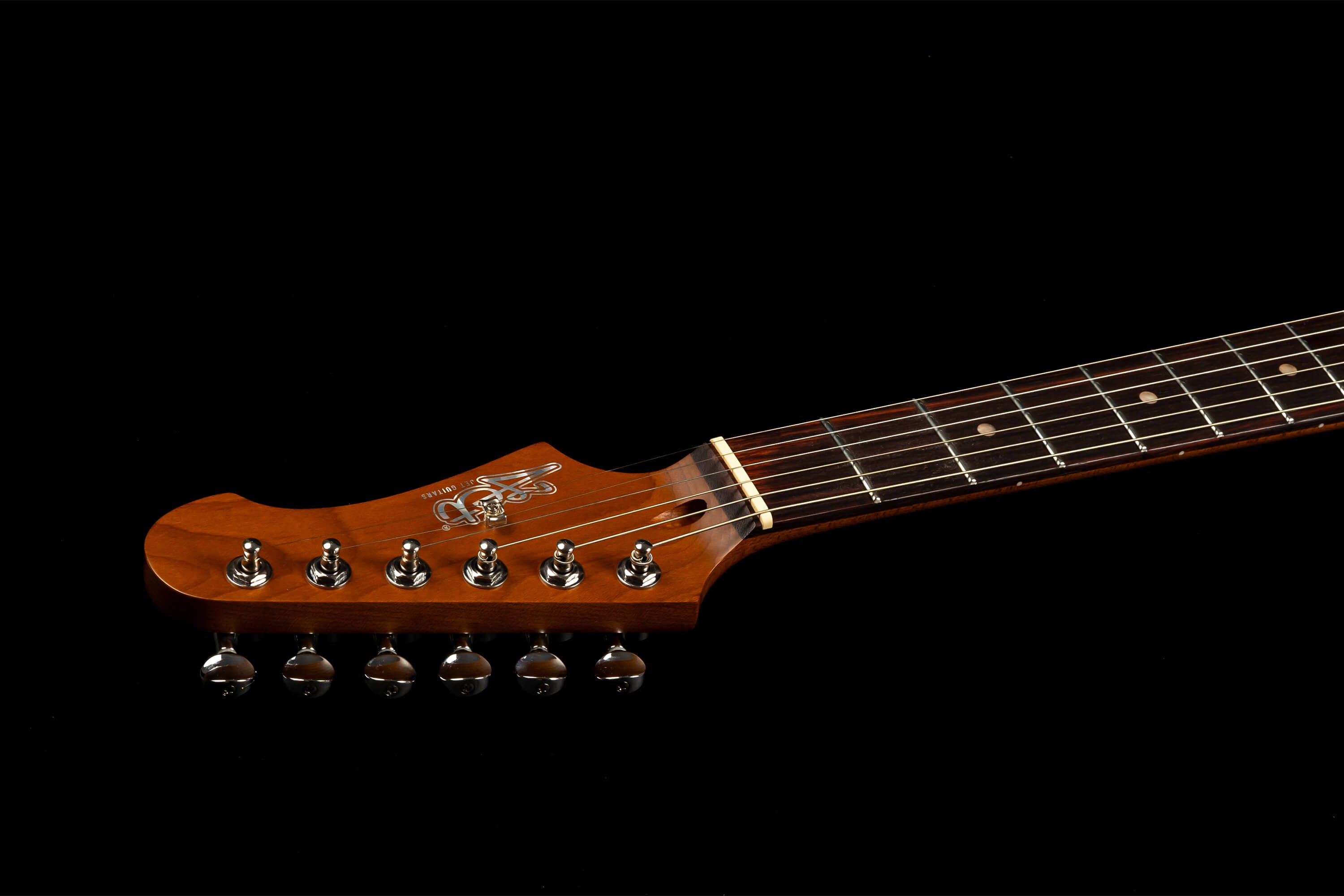 Wooden electric guitar headstock with six chrome tuning pegs, fretboard with dot markers, and decorative inlay on the headstock.
