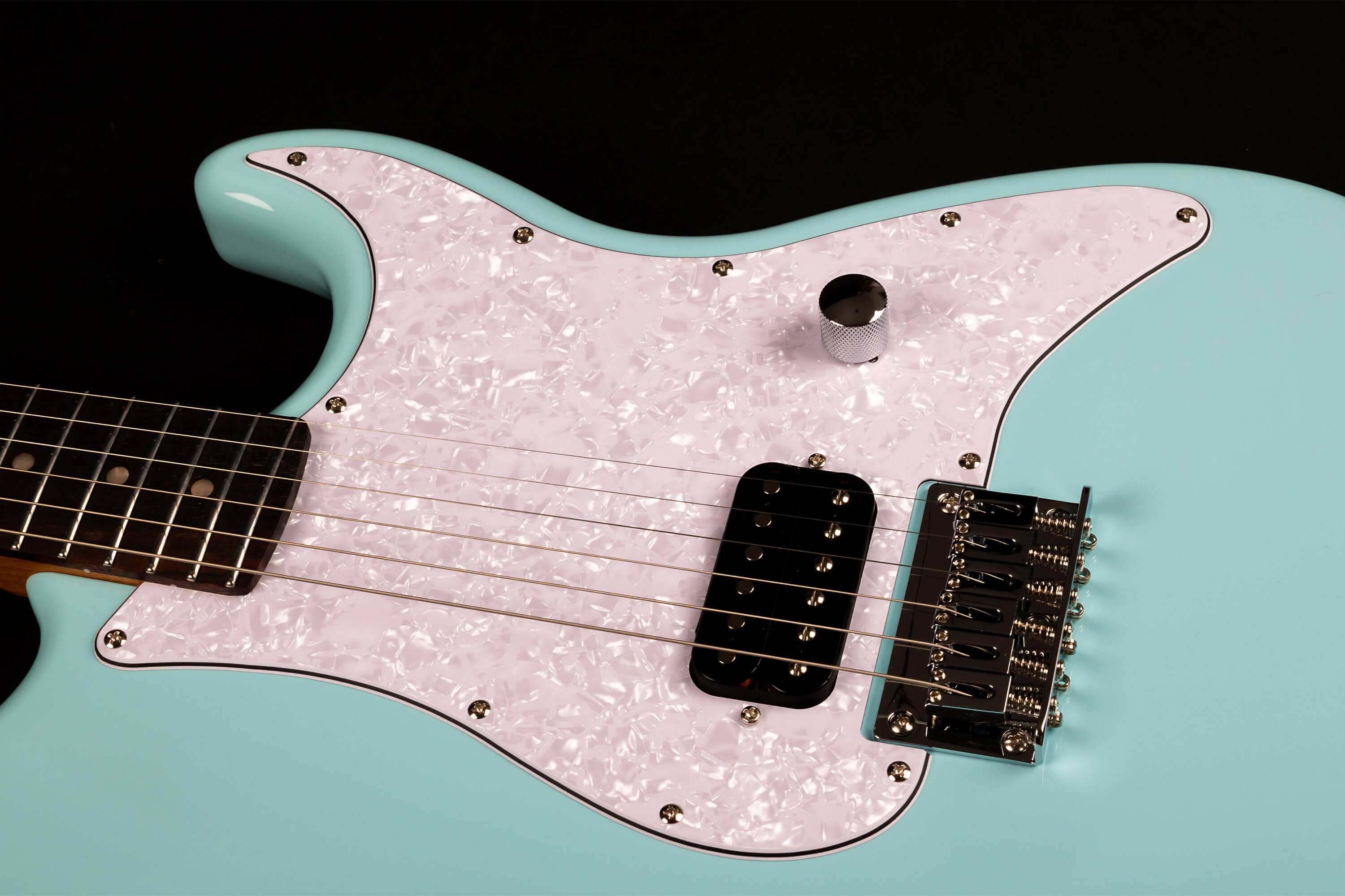 A light blue electric guitar with a white pearloid pickguard, single black pickup, one silver control knob, and a chrome bridge.